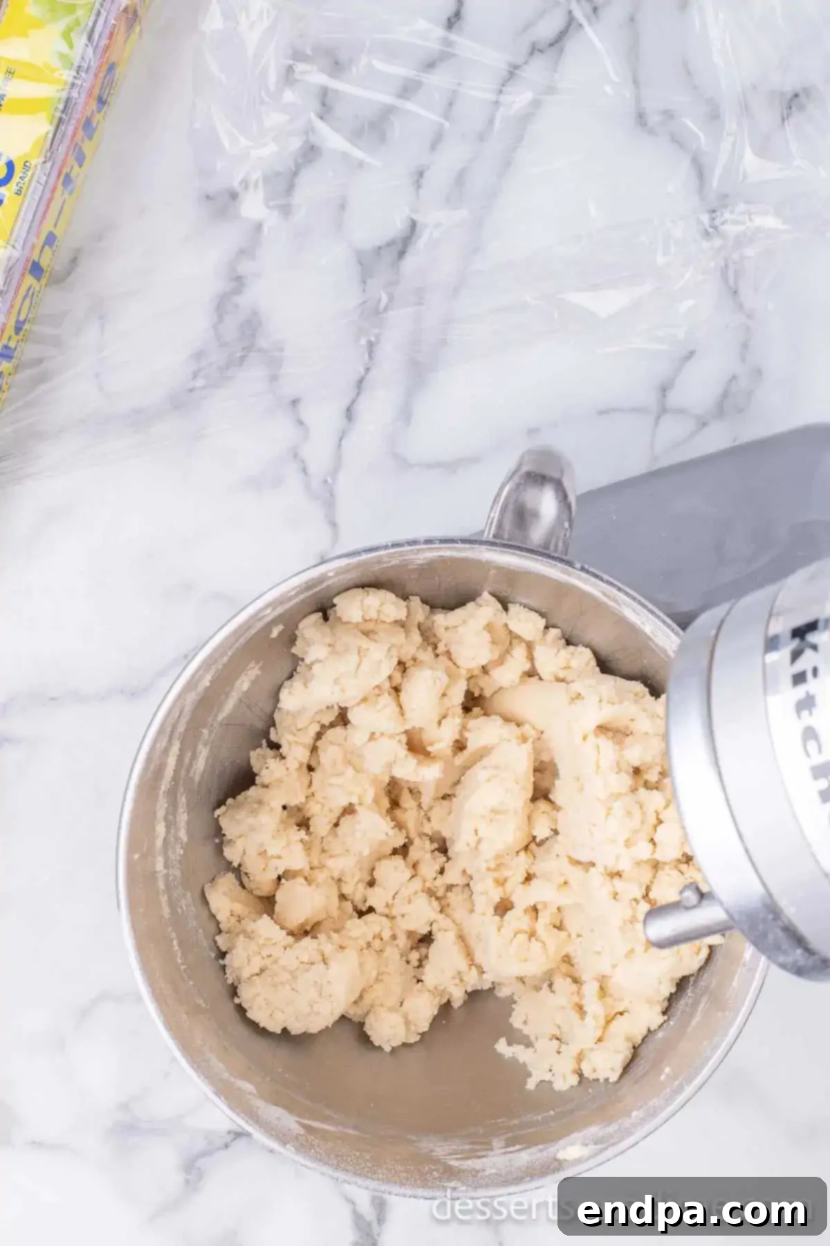 The sifted dry ingredients being added to the wet butter and sugar mixture in a large mixing bowl, ready to be combined.