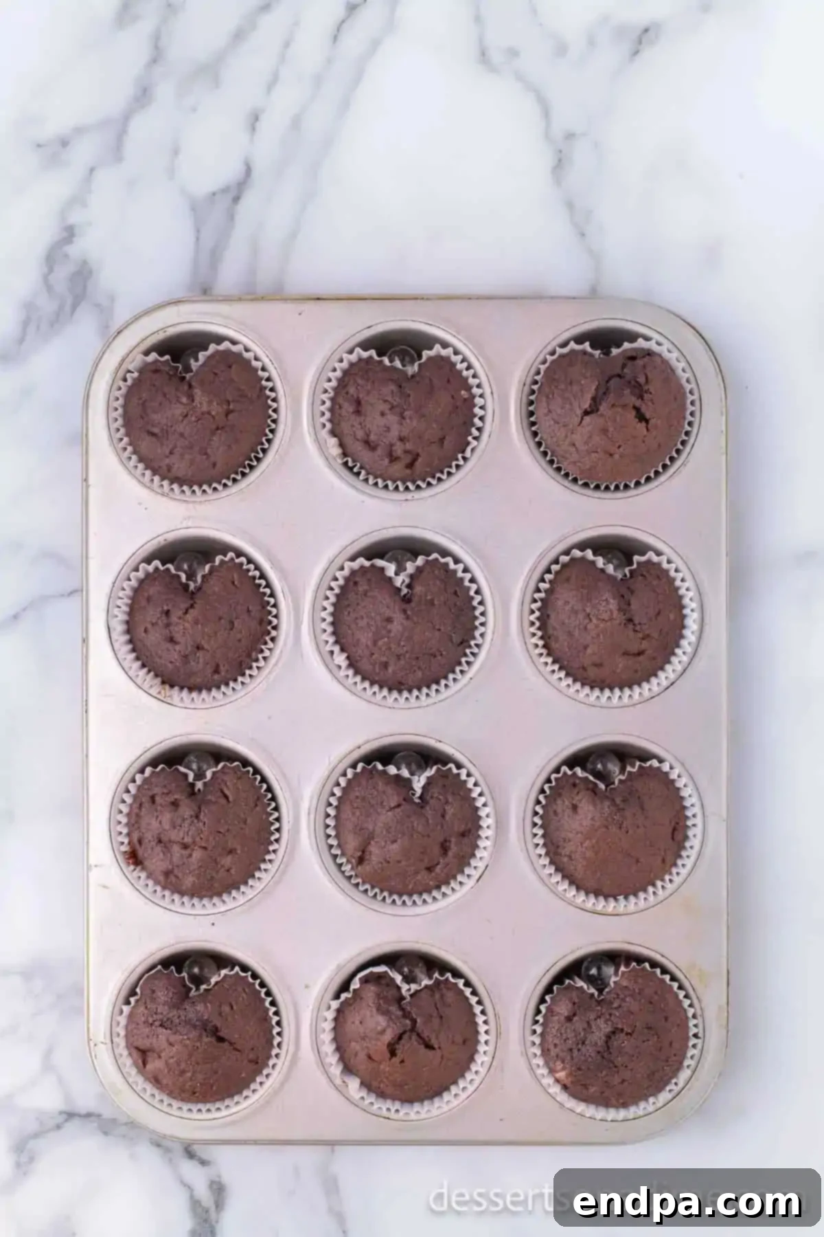 Cupid's Cupcakes 6 Baked heart-shaped cupcakes cooling on a wire rack.