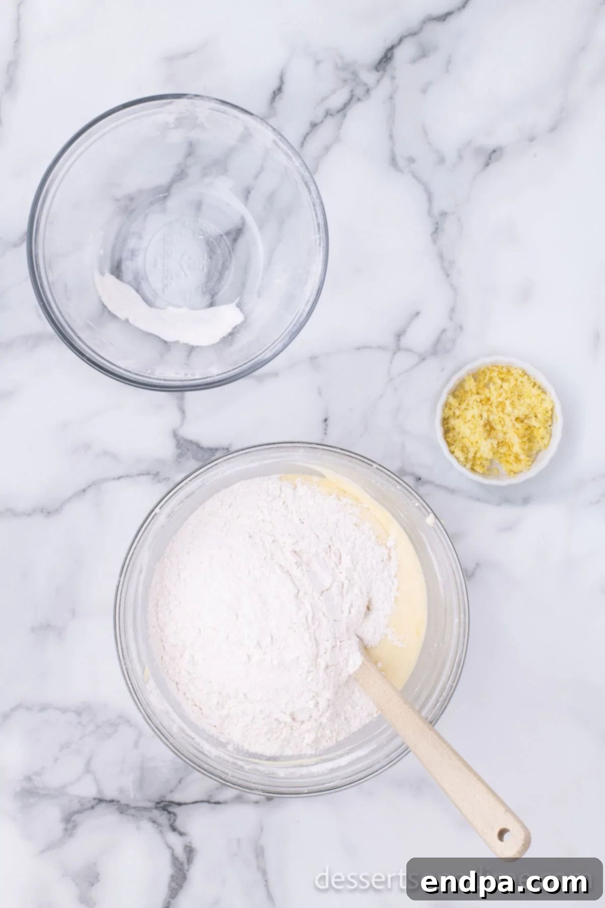 Starbucks Famous Lemon Loaf At Home 6 Flour and other dry ingredients being added to the wet ingredients in a mixing bowl.