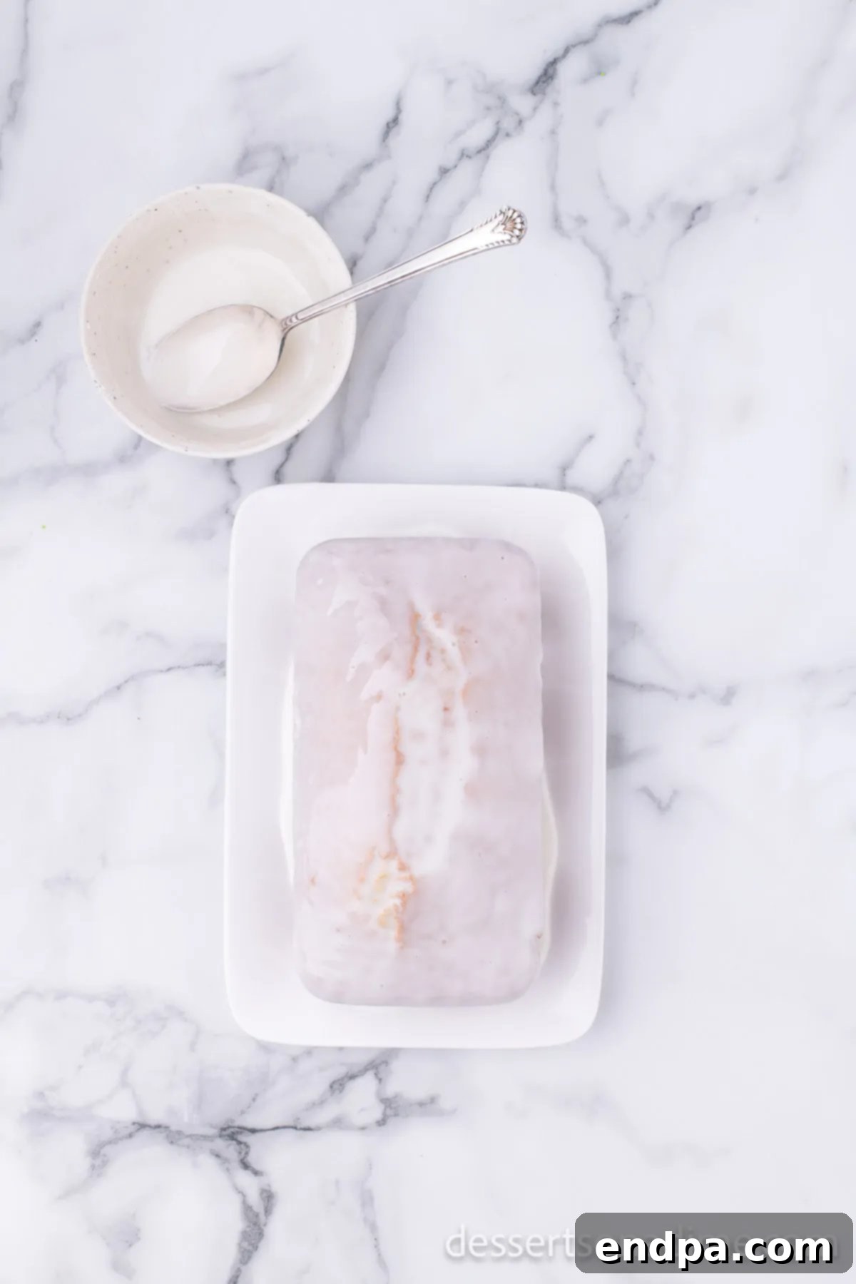 Starbucks Famous Lemon Loaf At Home 9 Sweet lemon glaze being drizzled over a cooled lemon loaf, creating a beautiful finish.