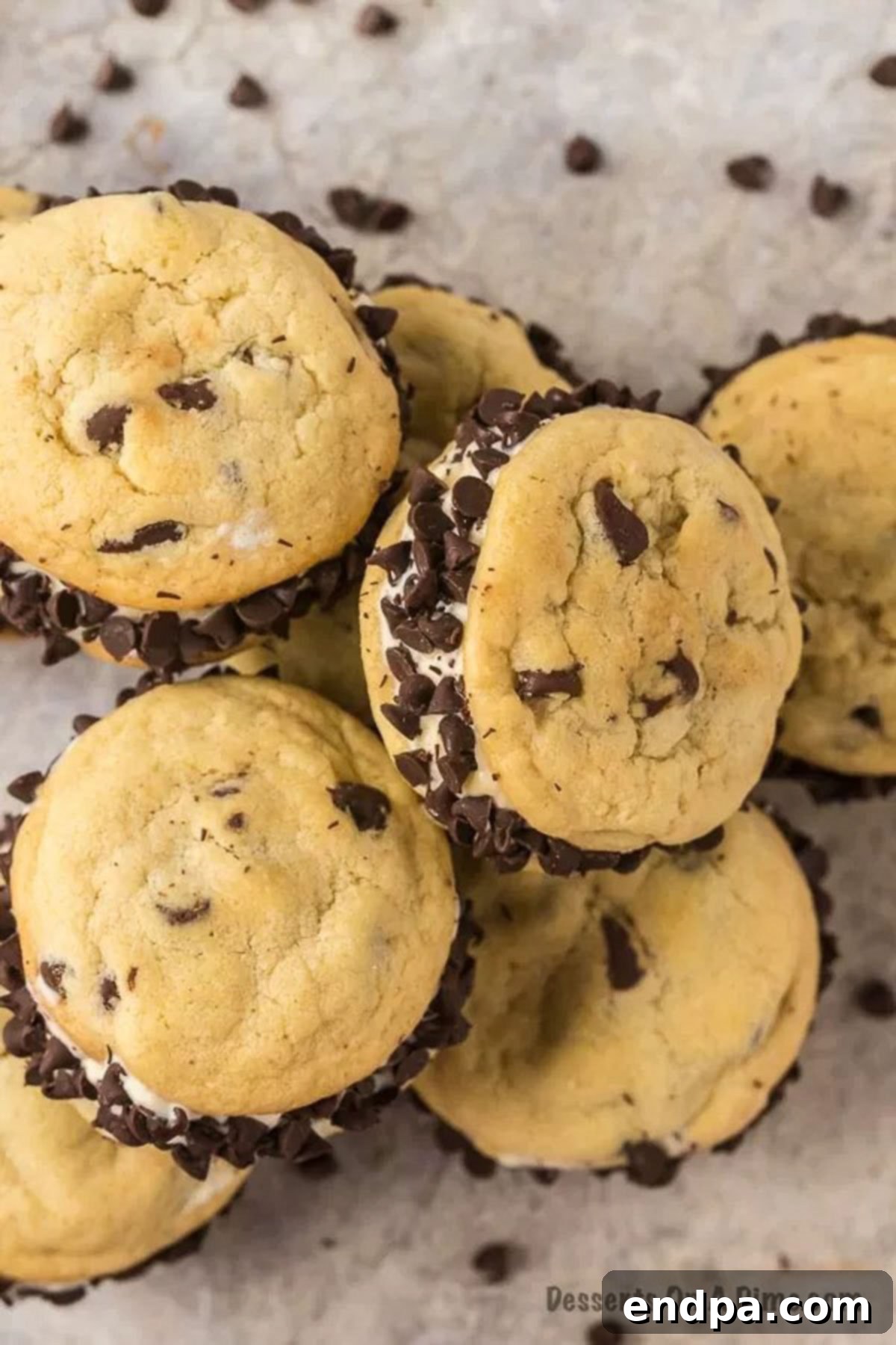 Homemade Chipwich ice cream sandwiches stacked in a pile, showcasing their rich chocolate chip coating and creamy ice cream filling.