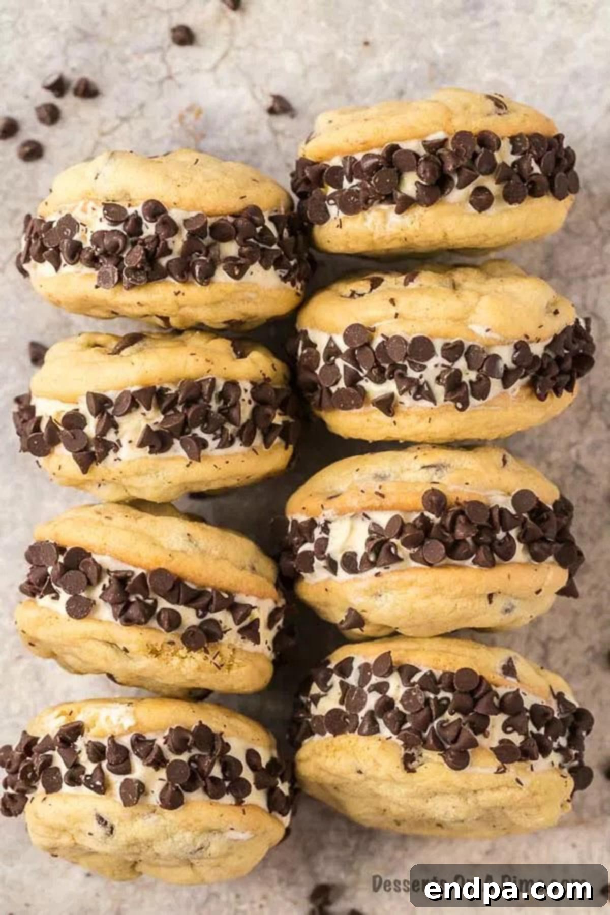 A close-up shot of several homemade Chipwich ice cream sandwiches, showcasing their thick ice cream filling and abundant chocolate chip coating.