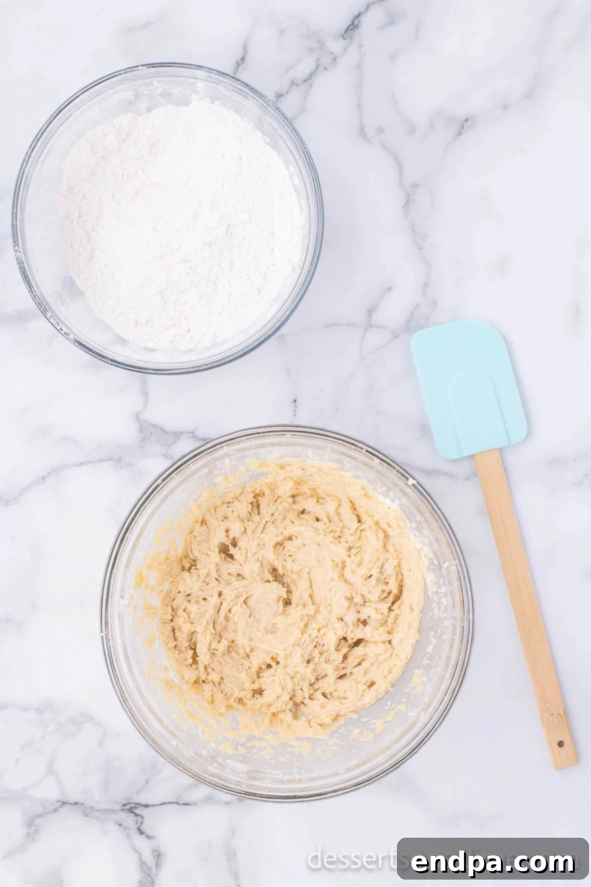 The bowl of wet ingredients and the bowl of dry ingredients placed side-by-side, prepared for mixing to form the cookie dough.