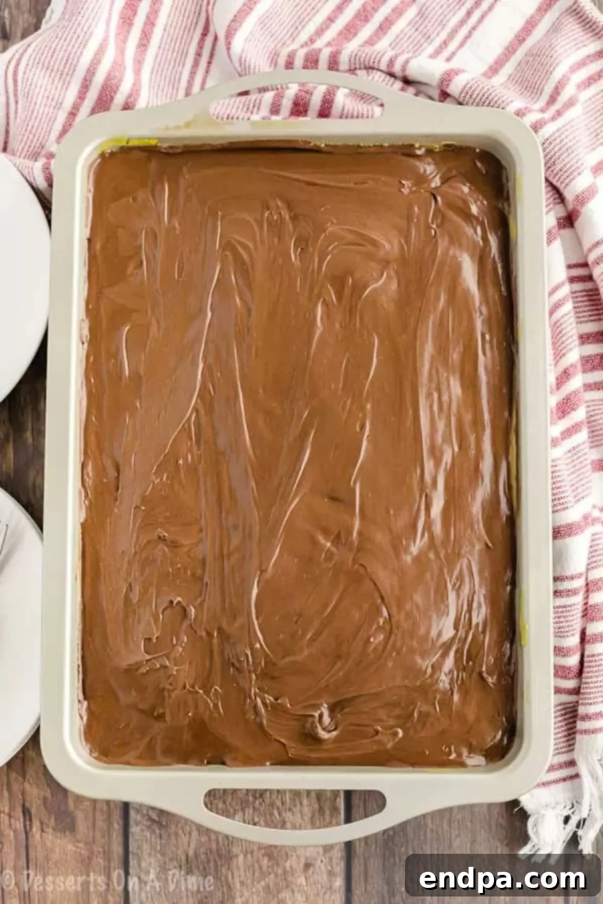 Chocolate frosting spread over the cake. 