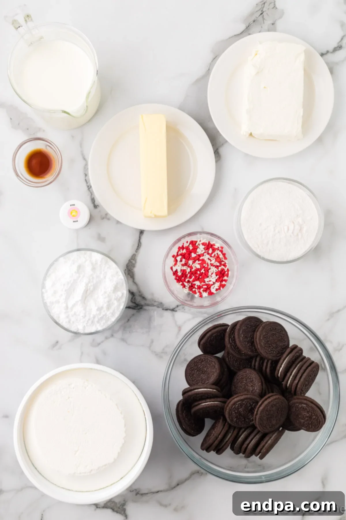 Ingredients for recipe - oreo cookies, cream cheese, butter, cool whip, vanilla pudding mix, pink food coloring and sprinkles.