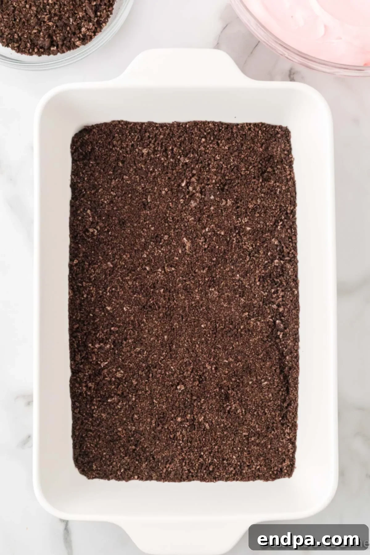 Crushed oreo cookies in baking dish.