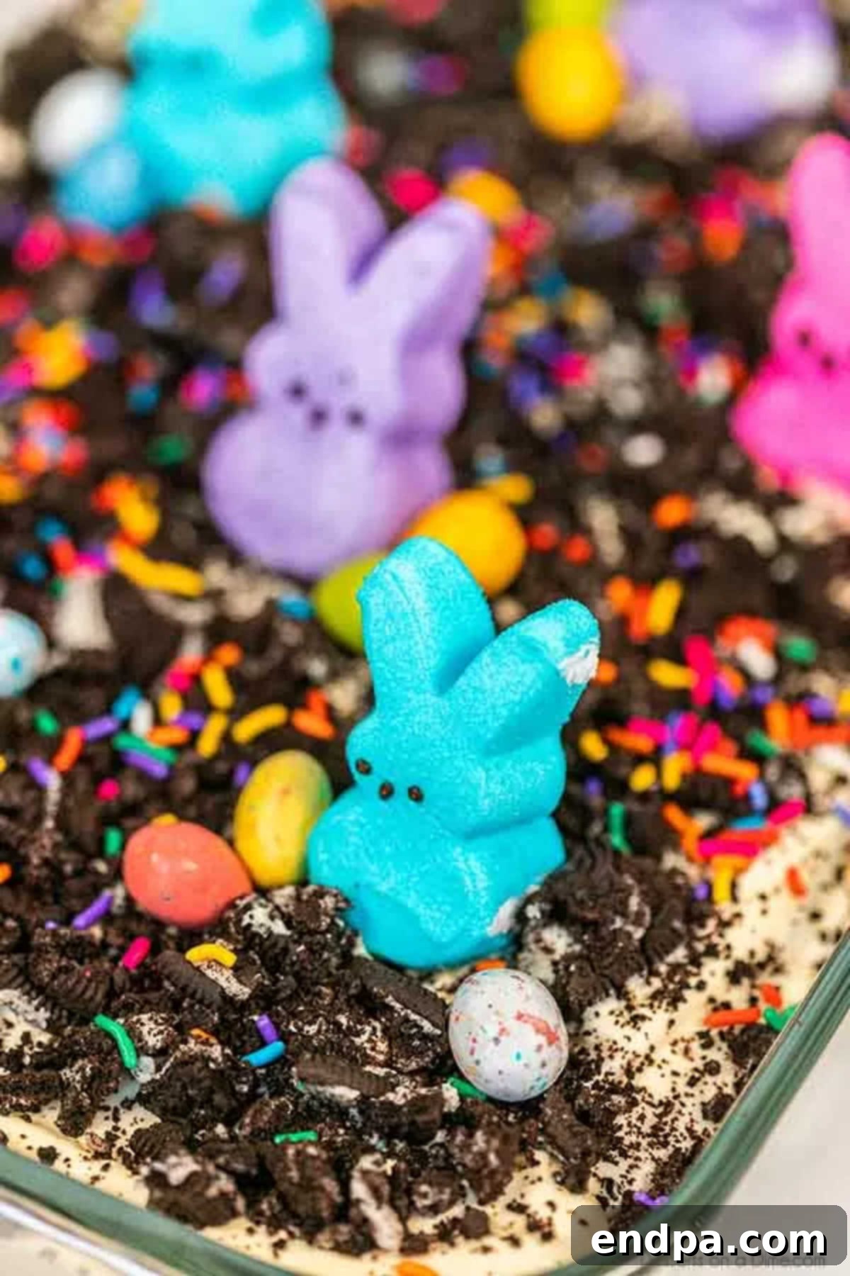 Easter dirt cake is an easy and delicious no bake treat perfect for dessert on Easter. This fun dessert is decorated with Easter peeps, candy and more. The fully assembled Easter dirt cake, chilled and ready to be decorated for Easter.