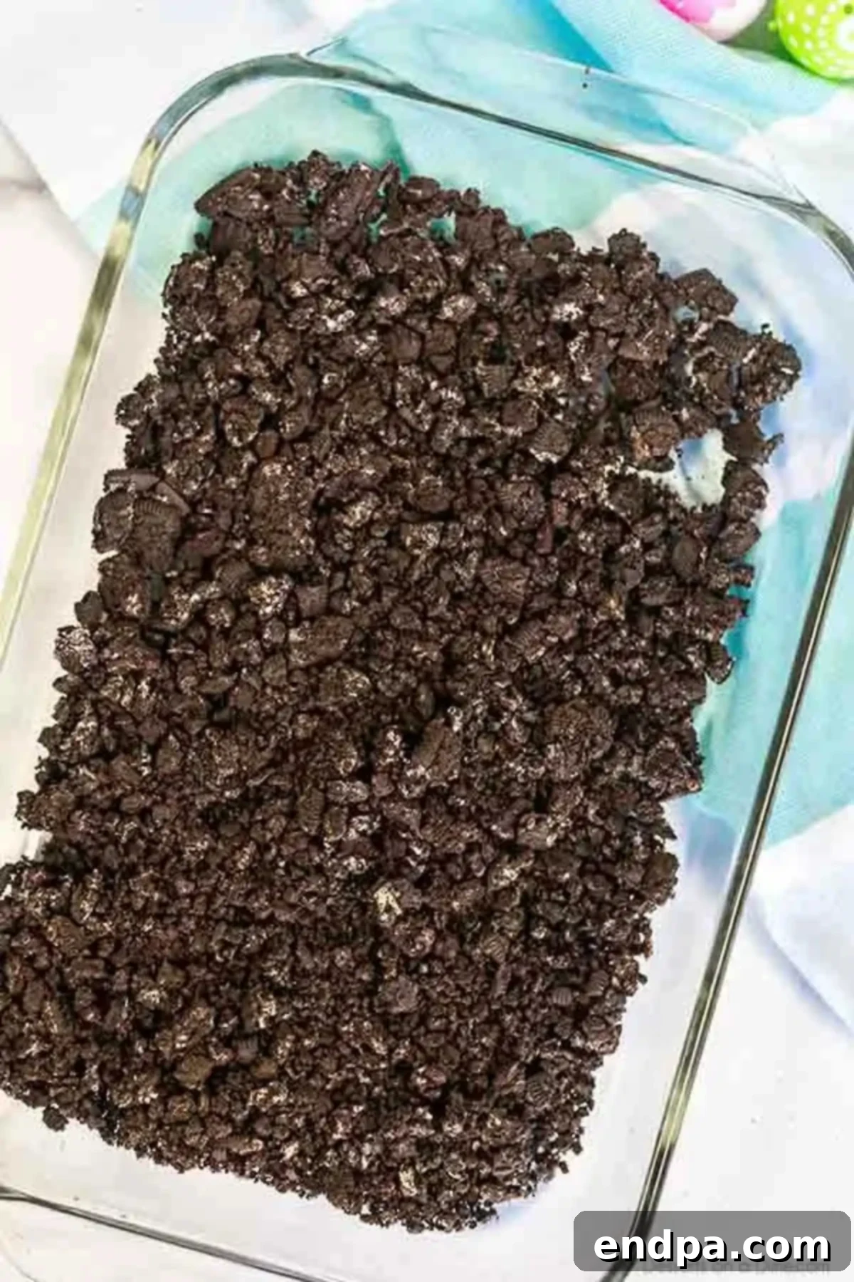 Spring Garden Dirt Cake 2 Crushed Oreo cookies forming the base layer in a baking pan.