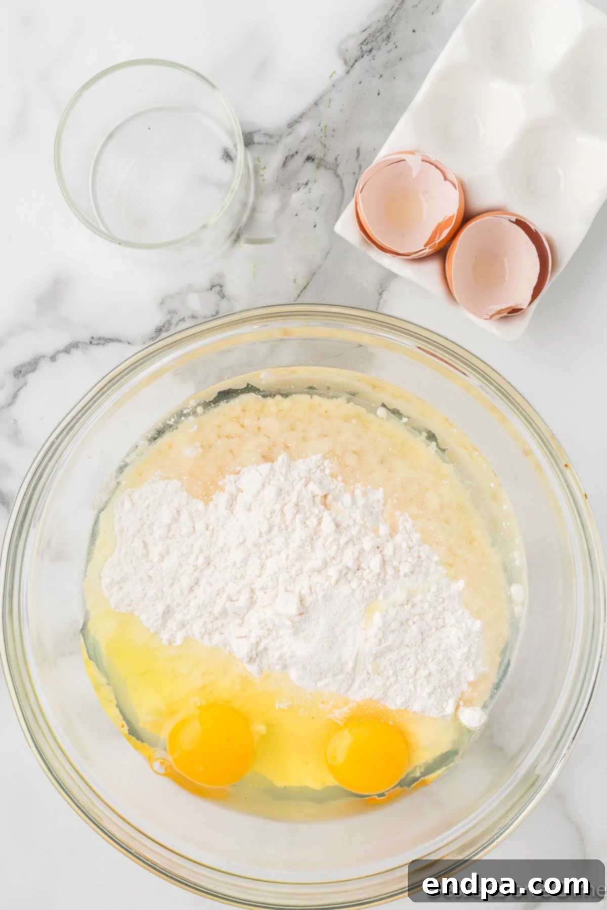 Eggs and oil being added to the cake mix in a large bowl.