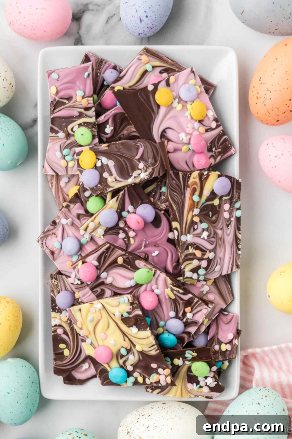 Assorted broken pieces of Easter chocolate bark on an elegant serving platter.