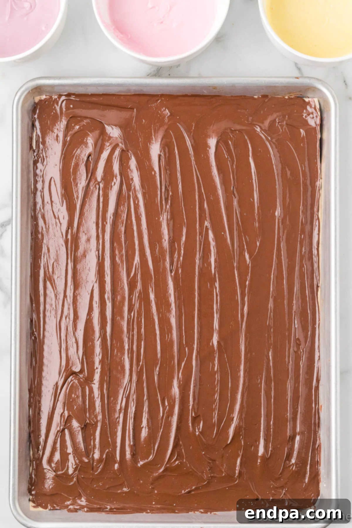 Melted semi-sweet chocolate spread evenly across a lined baking sheet.