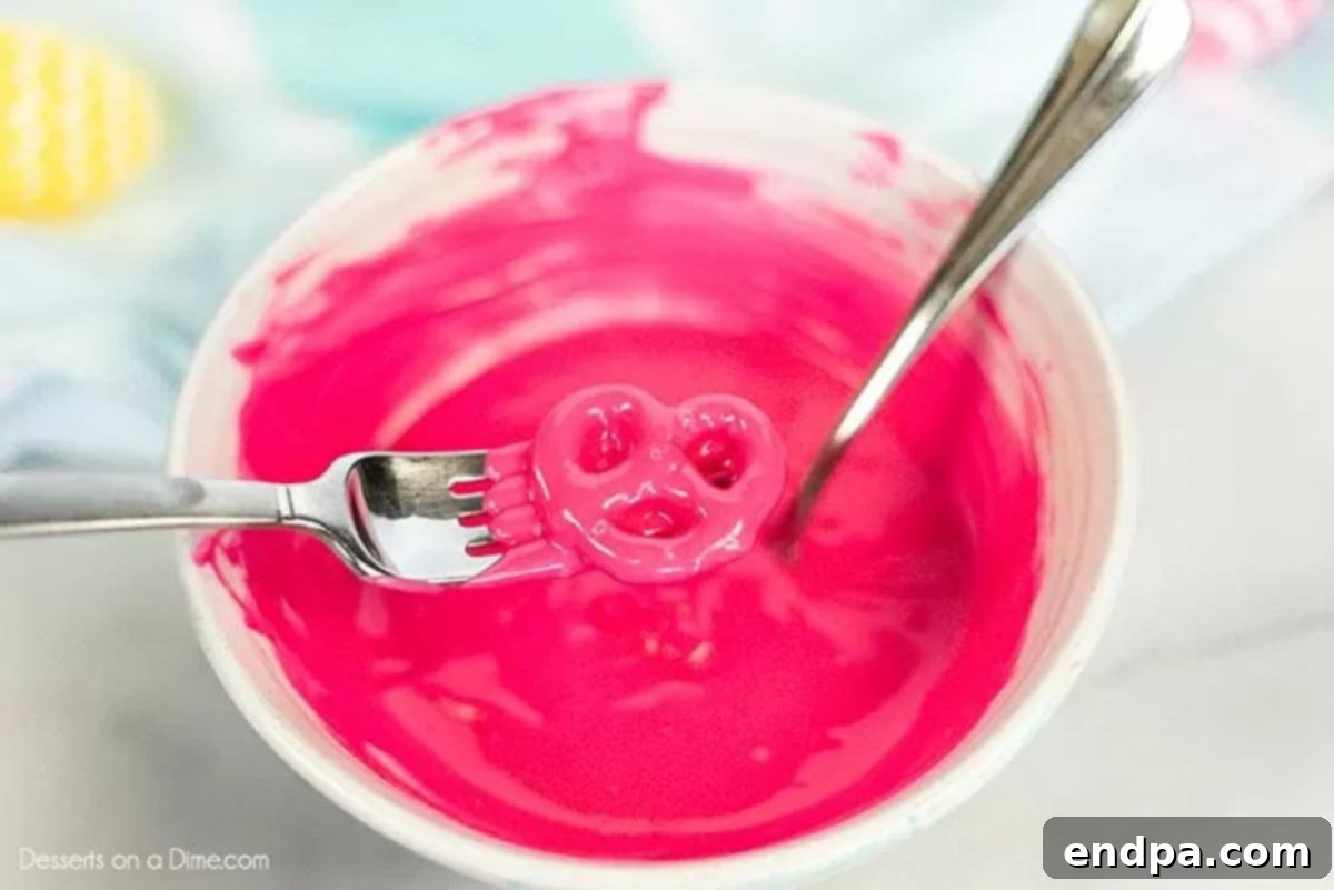 Melting the pink chocolate in a bowl with a pretzel on a fork