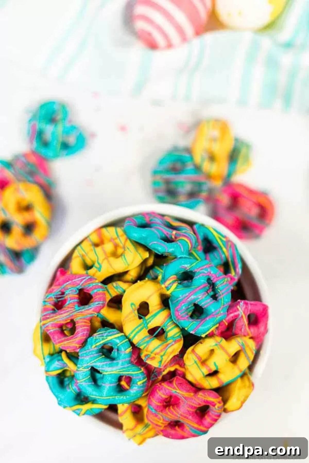 Pretzels coated in candy in a bowl. 