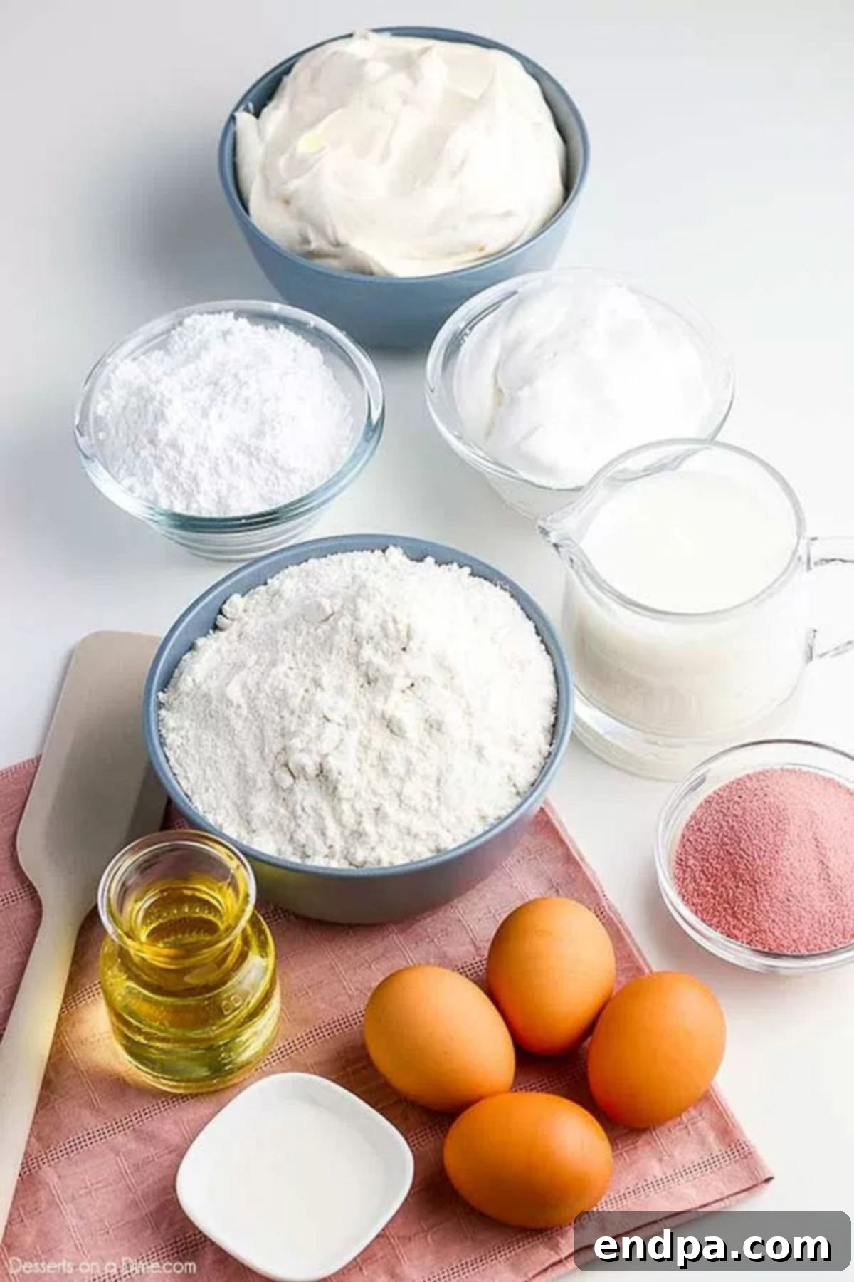Collection of ingredients to make cherry jello poke cake, including cake mix, eggs, oil, buttermilk, and cherry gelatin.