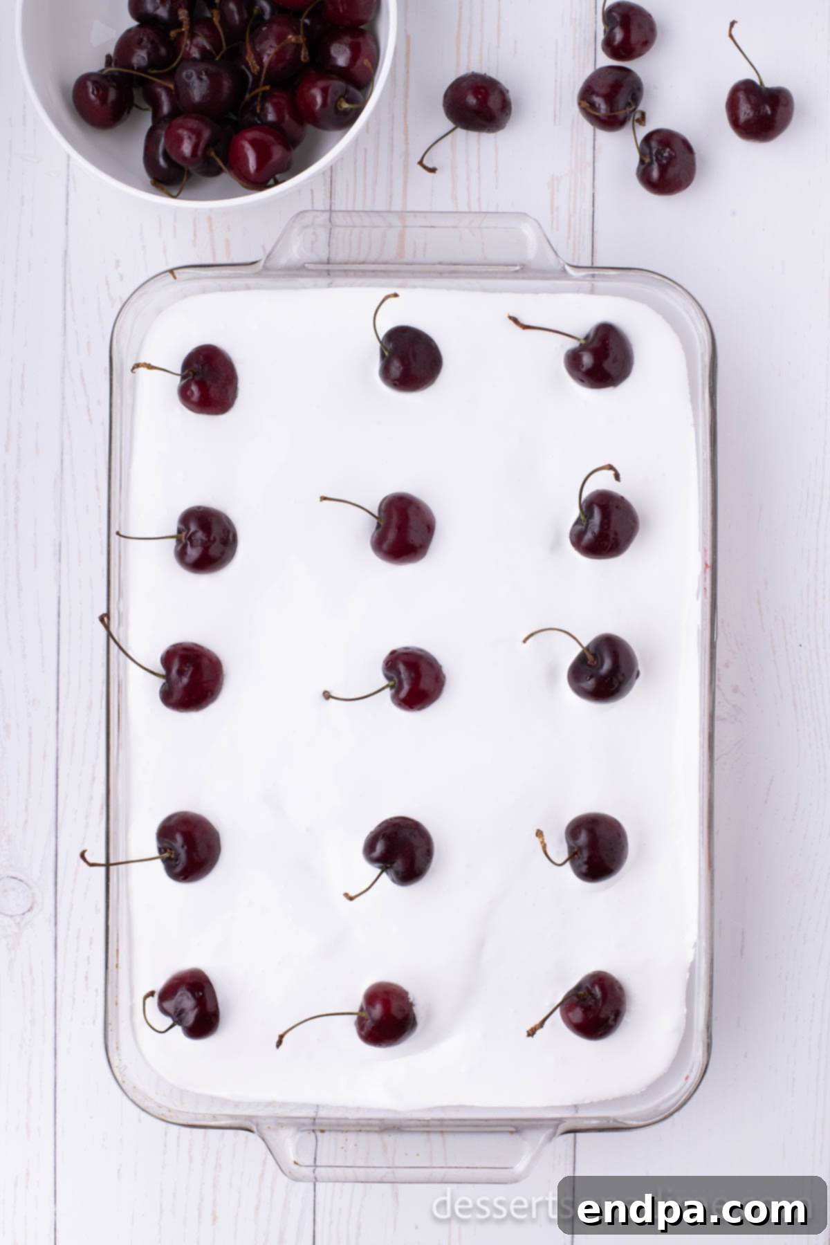 Finished cherry poke cake garnished with fresh cherries.