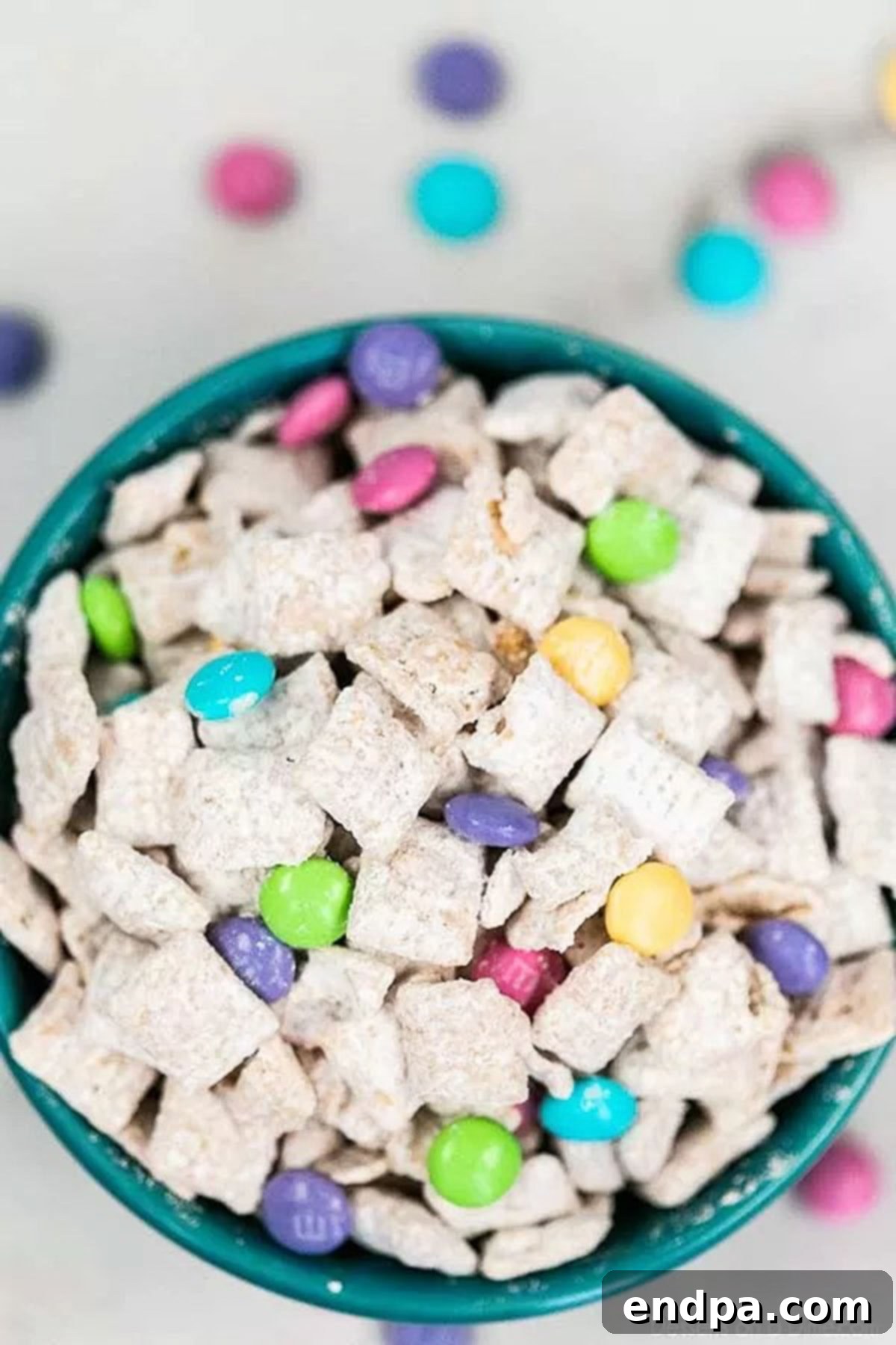 Close up bowl of vibrant Easter Bunny Chow mix with pastel M&M's.
