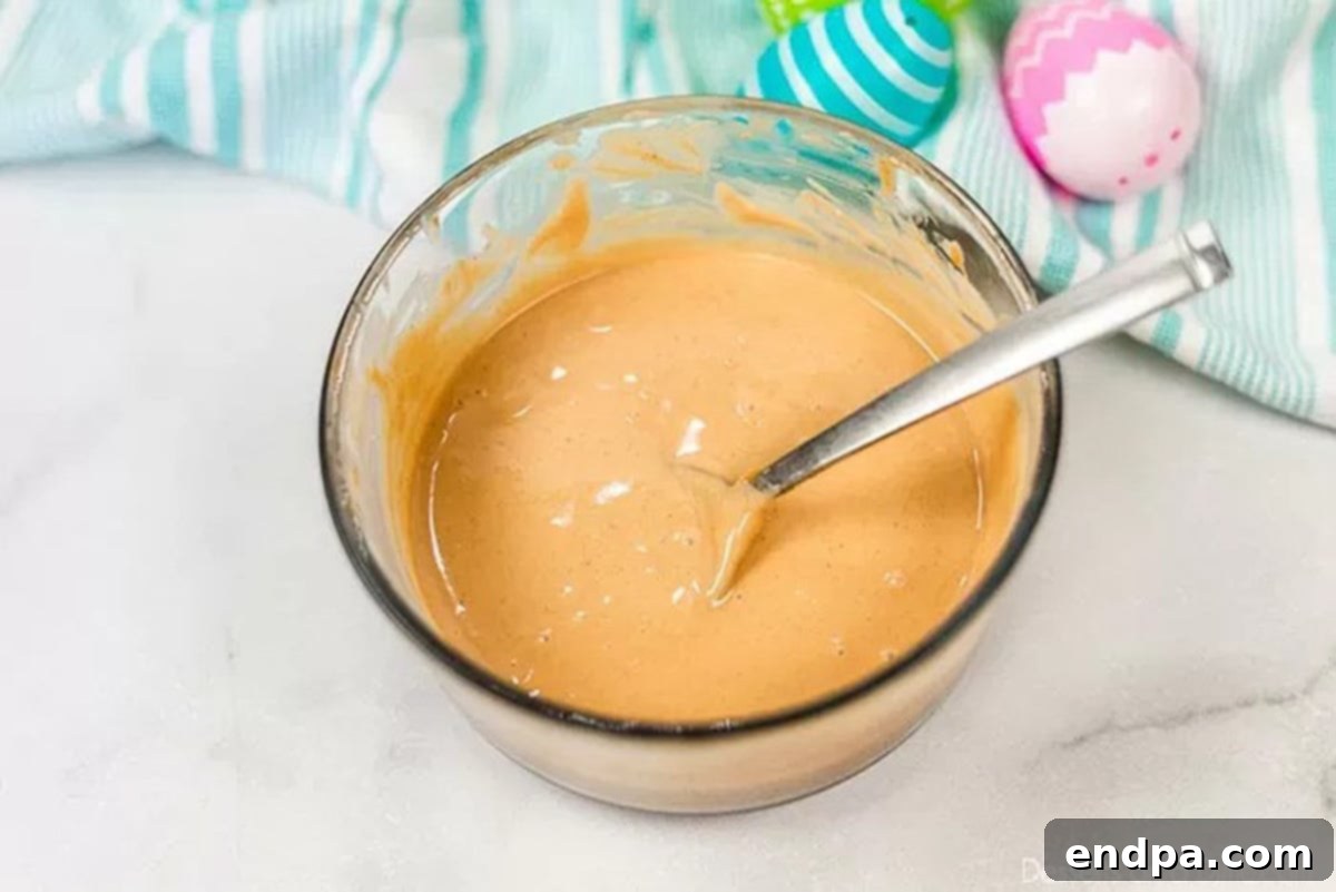Melted chocolate and peanut butter mixture in a bowl, smooth and ready to coat cereal.