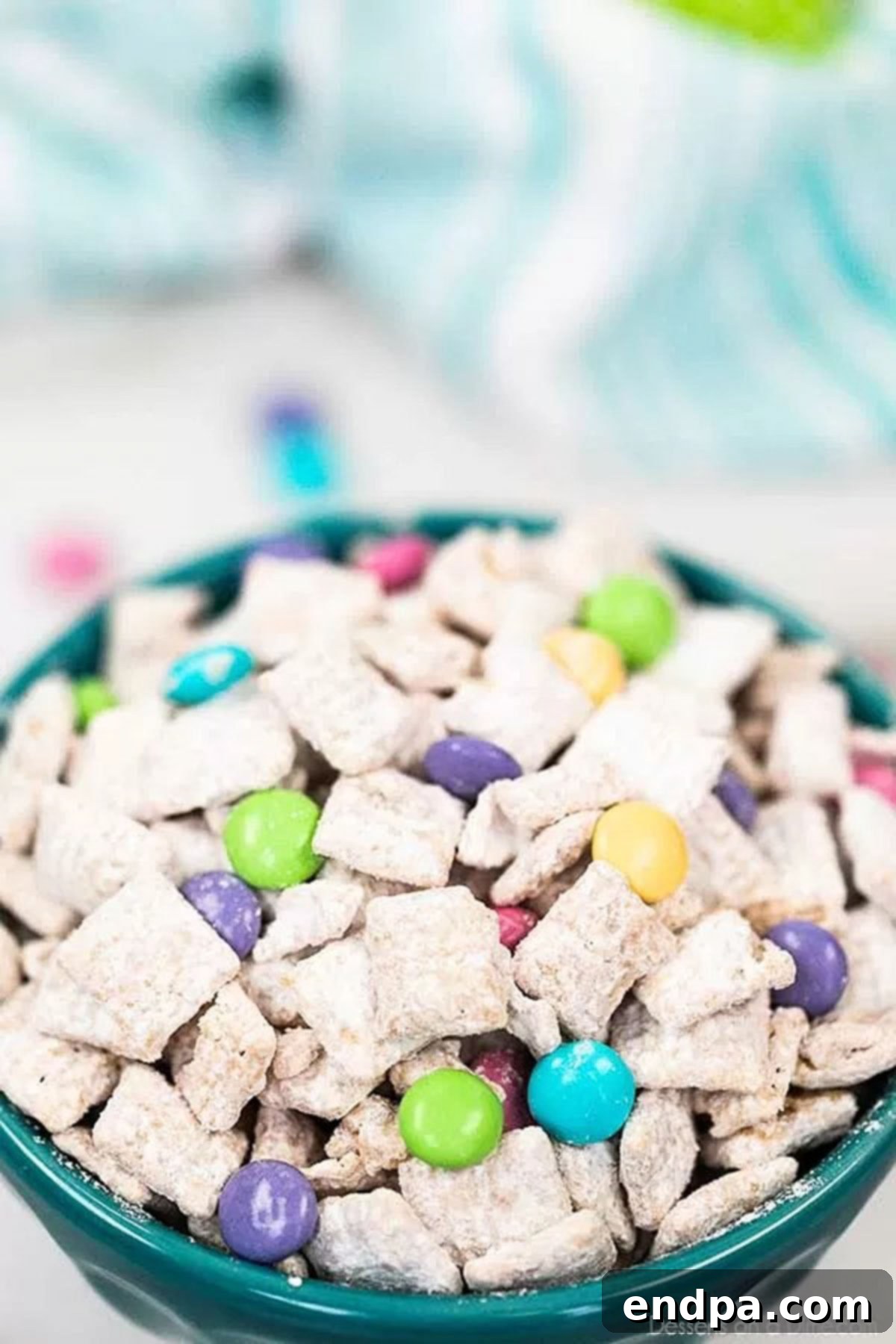 Close up bowl of bunny chow mix with pastel candies, ready to serve.