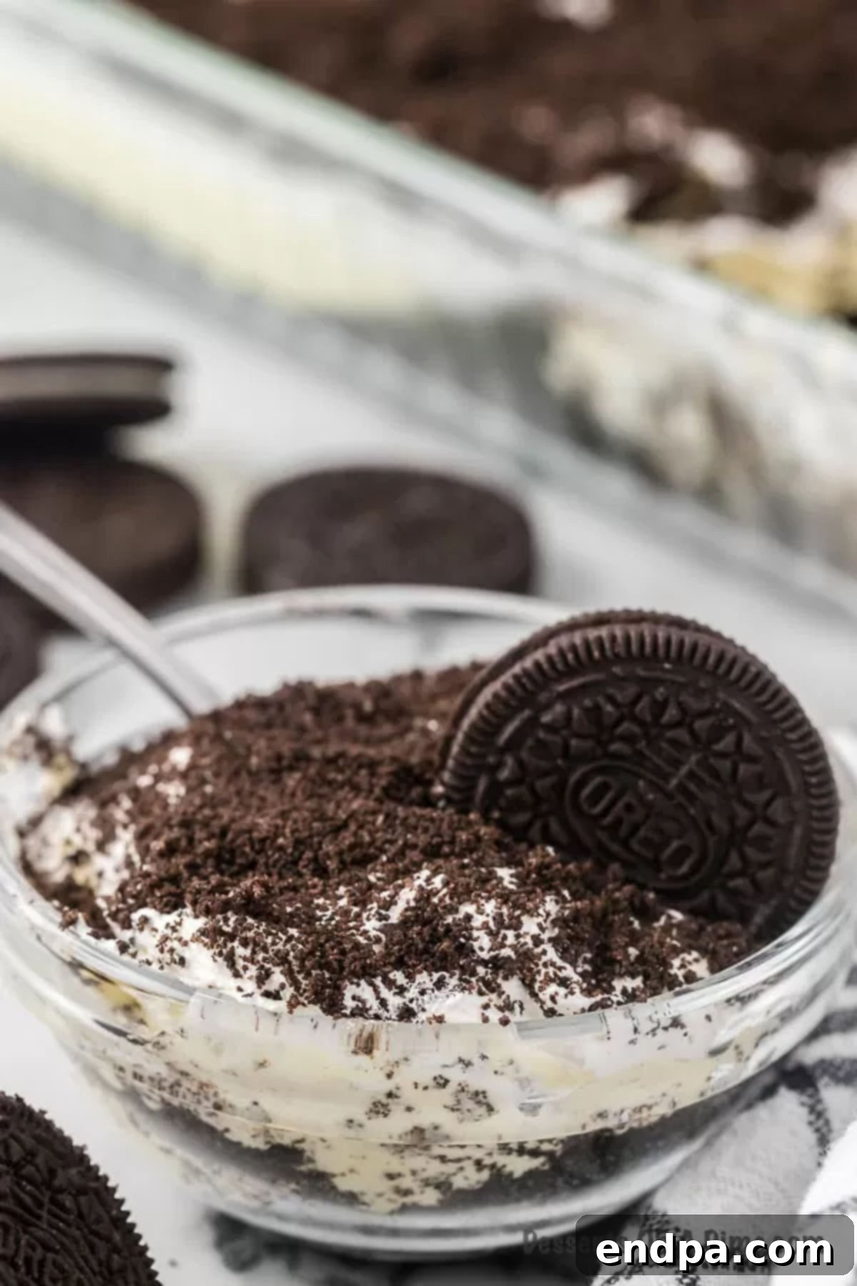 A serving of creamy Dirt Cake, prepared without cream cheese, in a clear bowl.