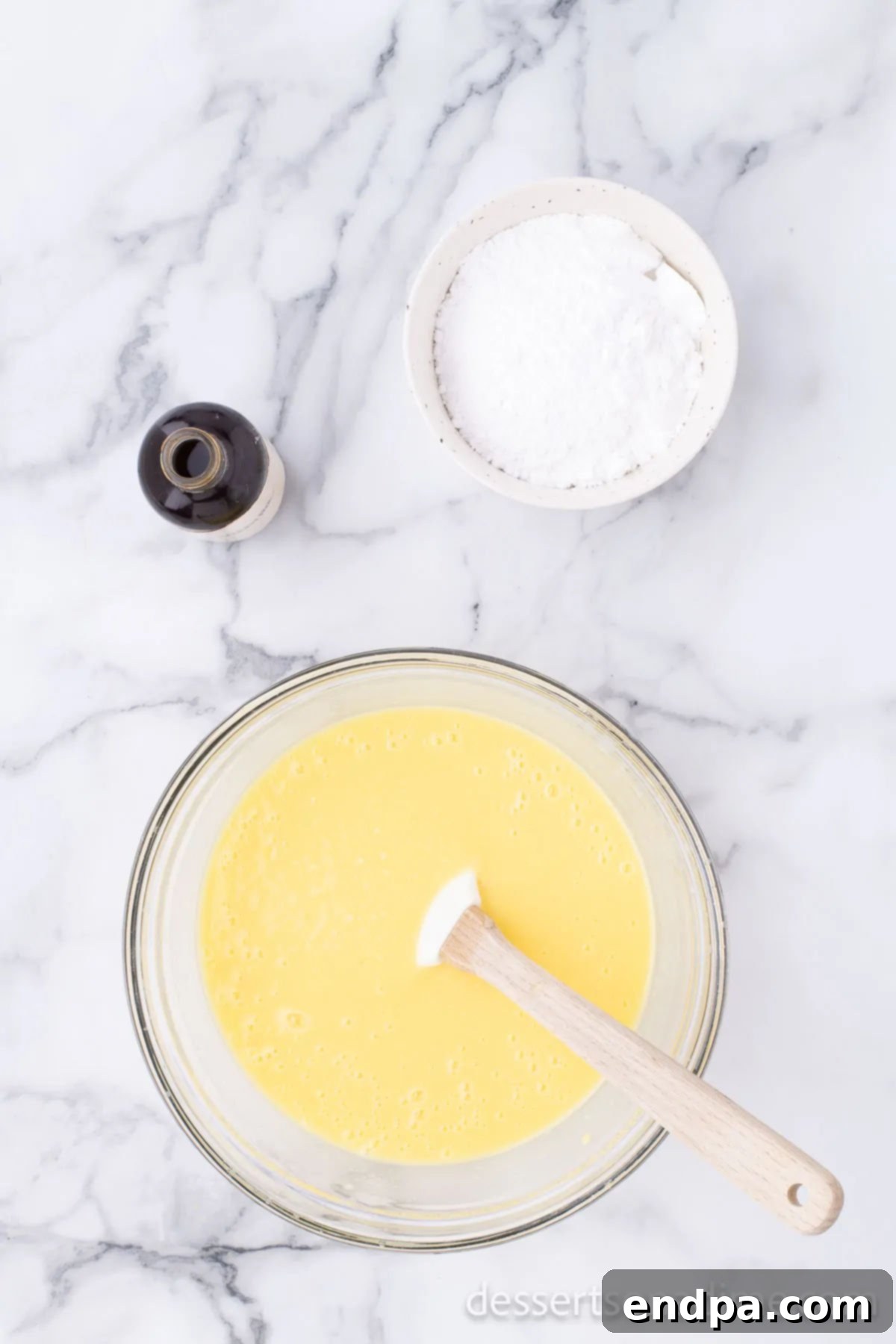 Instant vanilla pudding mix being poured into a mixing bowl, ready to be combined with milk.
