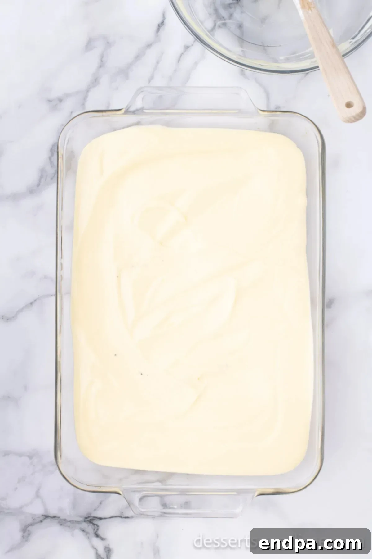 The smooth, creamy pudding and whipped topping mixture spread evenly over the Oreo crumb base in the baking dish.