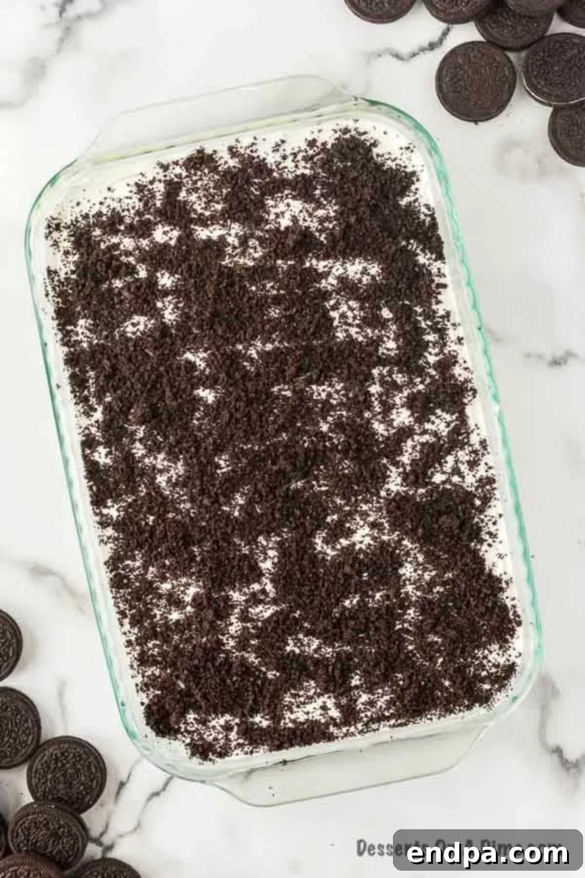 A freshly assembled Dirt Cake Recipe without Cream Cheese, chilling in a baking dish, ready for refrigeration.