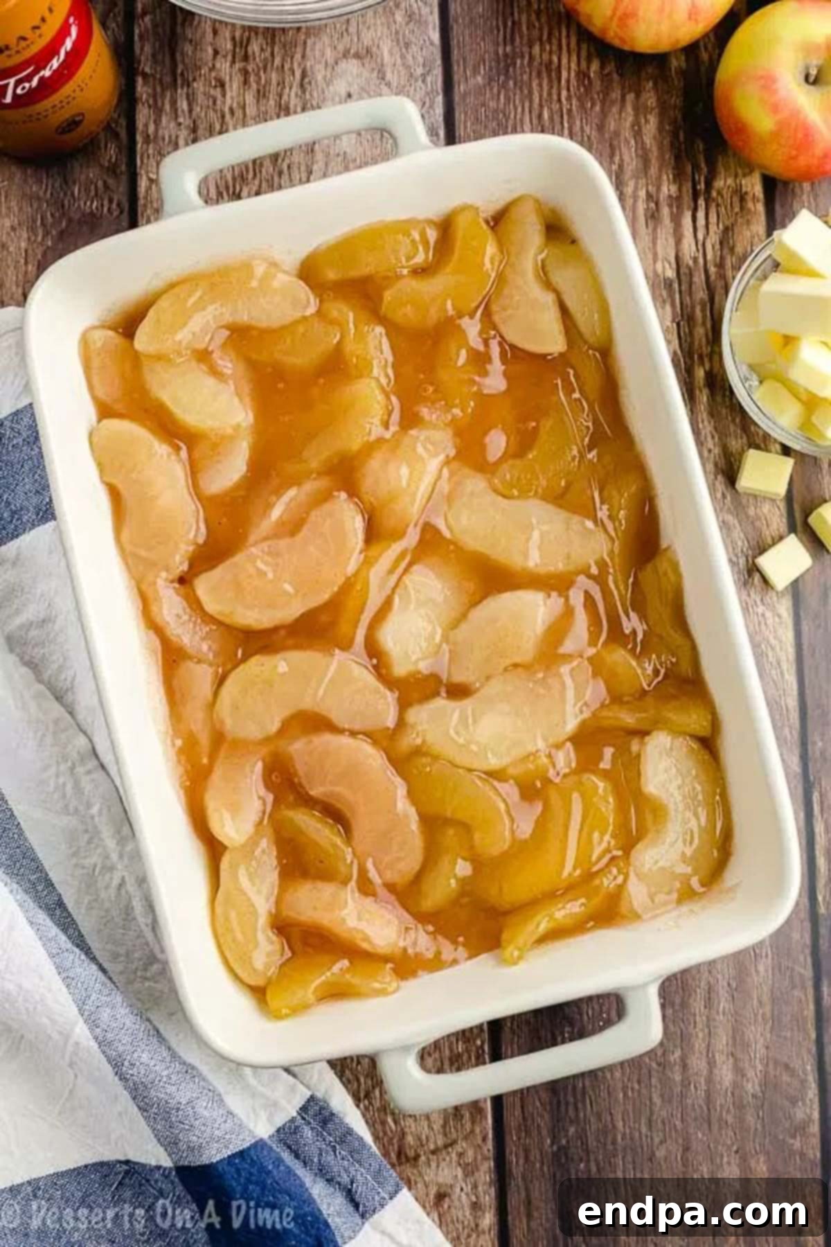 Apple pie filling spread evenly in the bottom of a glass baking dish.