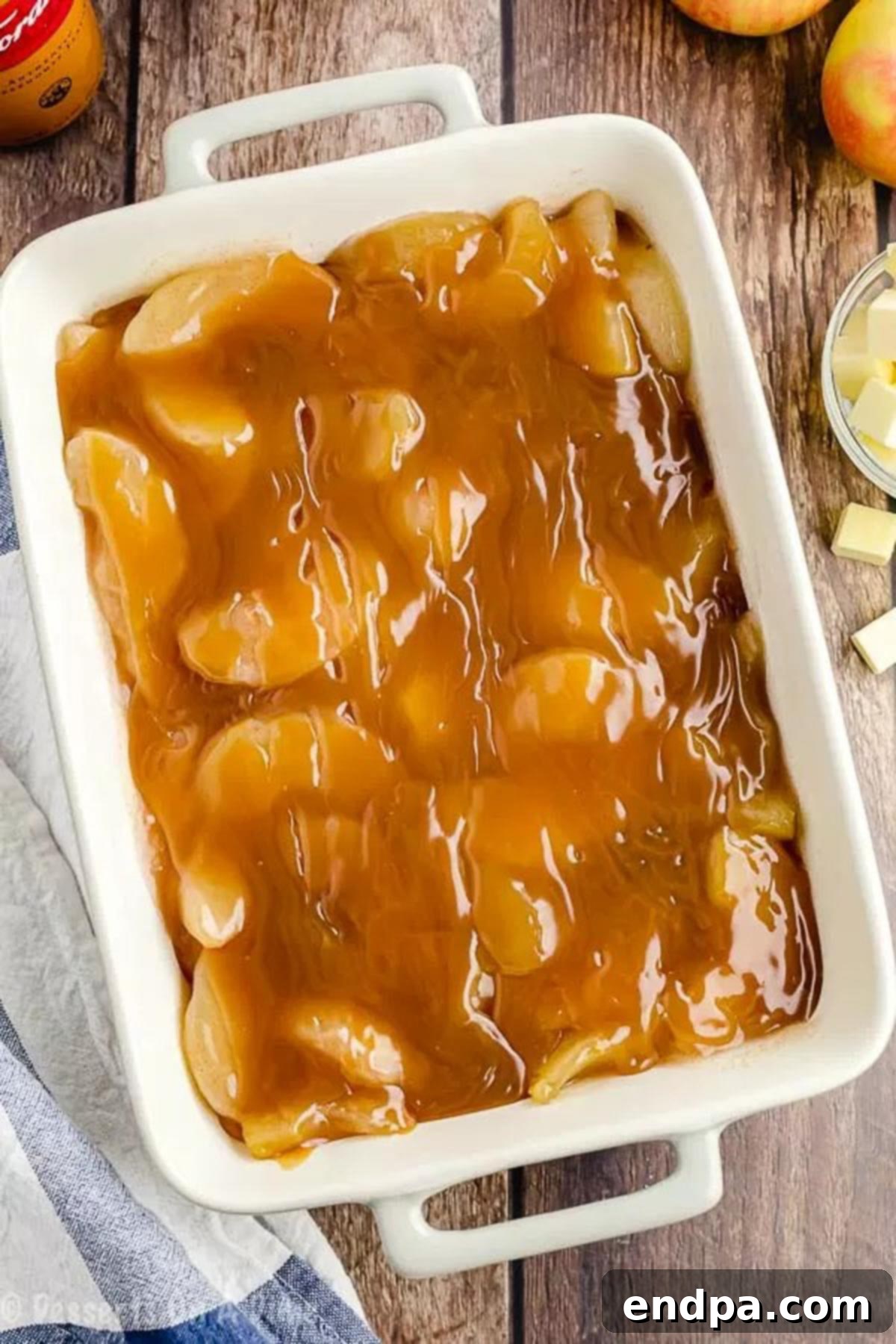 A generous layer of caramel sauce poured and spread over the apple pie filling.
