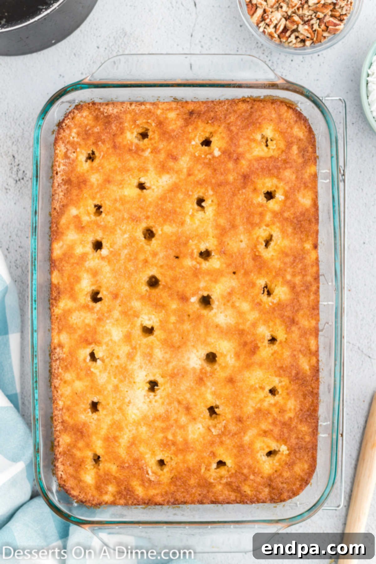 Freshly baked cake with evenly spaced holes poked across its surface.