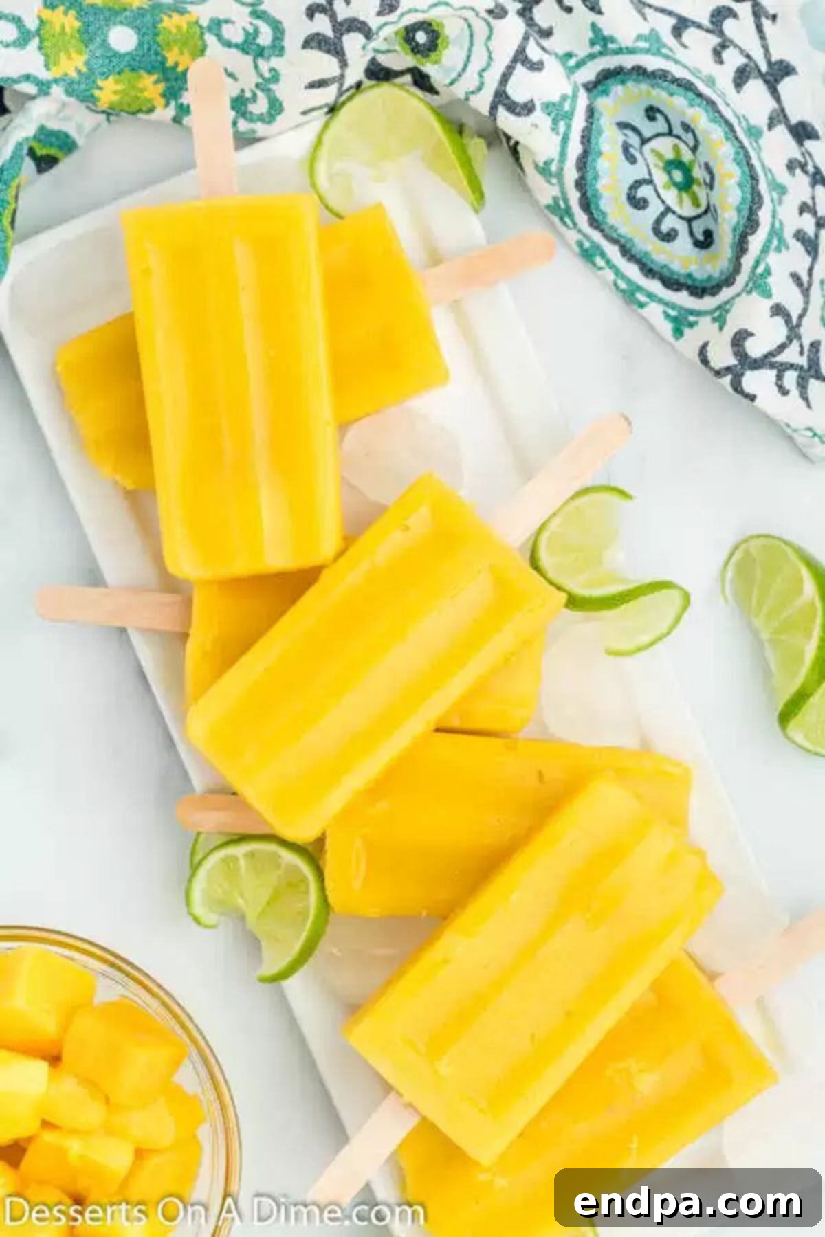 Freshly made Mango Popsicles arranged neatly on a serving tray, glistening in the light and ready to be enjoyed.