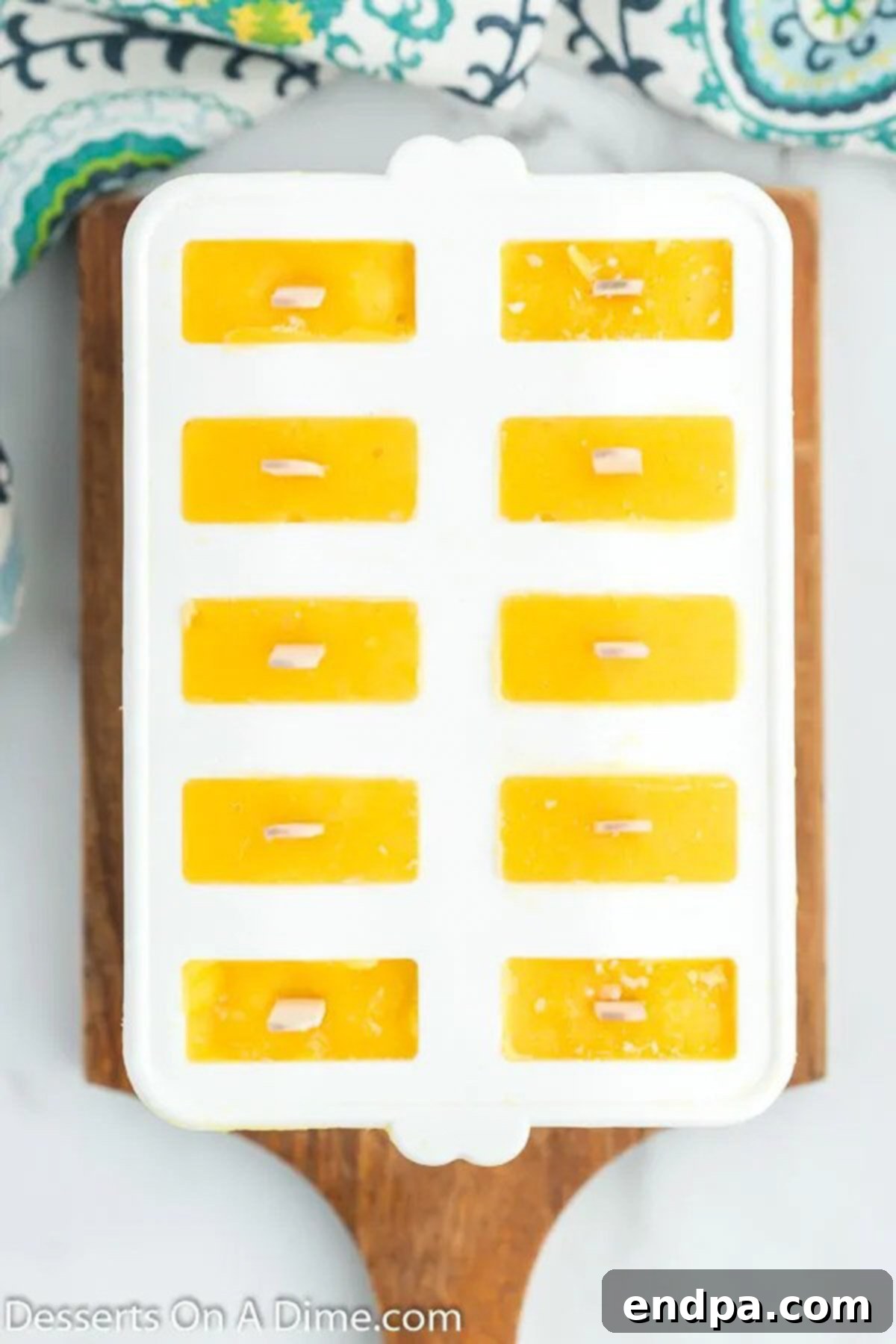 Popsicle sticks carefully inserted into each mold filled with mango mixture, ready for freezing.