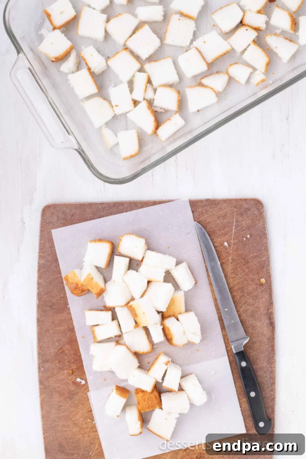 Angel food cake cut into uniform cubes, ready for layering in the baking dish.