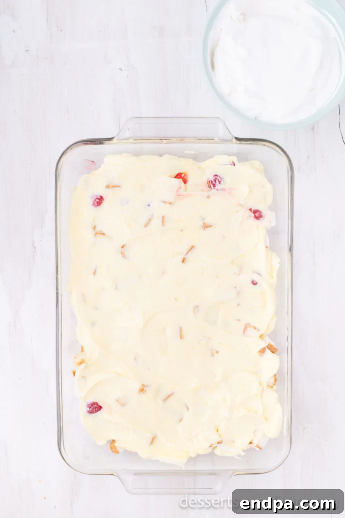The smooth pudding and sour cream mixture being carefully spread over the second cake layer.