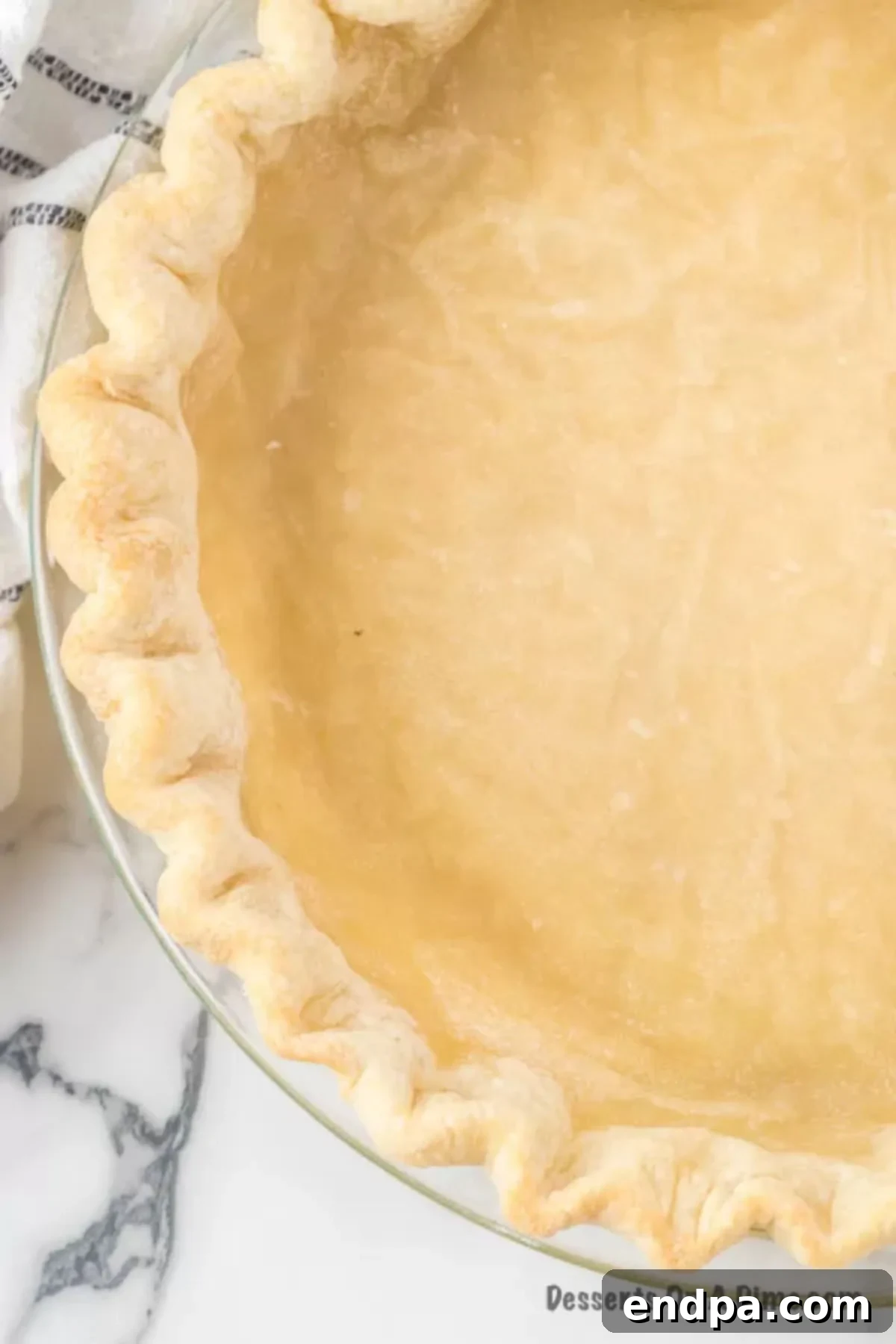 A perfectly baked 3-ingredient pie crust, golden brown and ready to be filled, set on a dark, elegant surface.