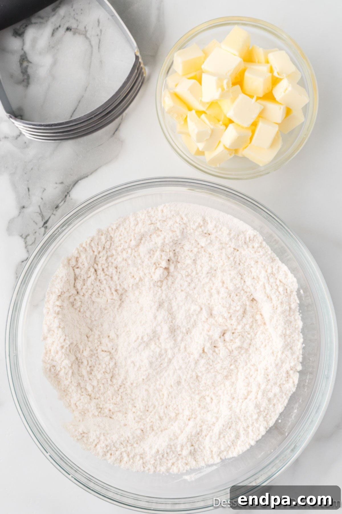A large mixing bowl containing white all-purpose flour and a pinch of salt, ready for whisking.