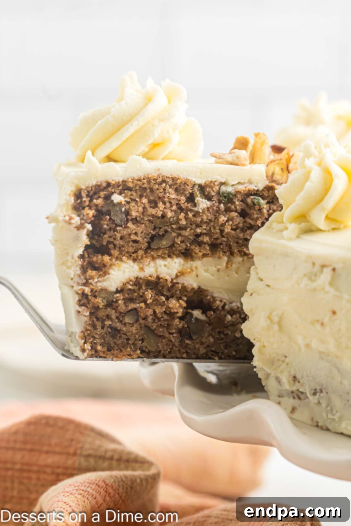 A perfectly sliced Keto Carrot Cake showing distinct layers of moist cake and rich cream cheese frosting.