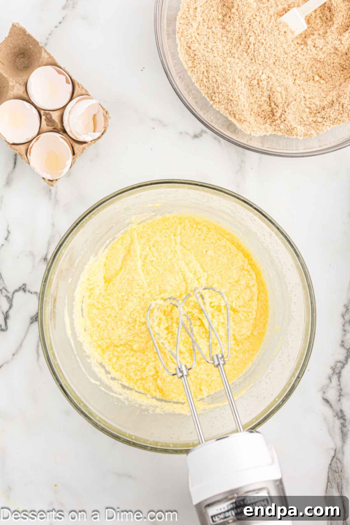 Vanilla extract and eggs being beaten into the creamed butter mixture.