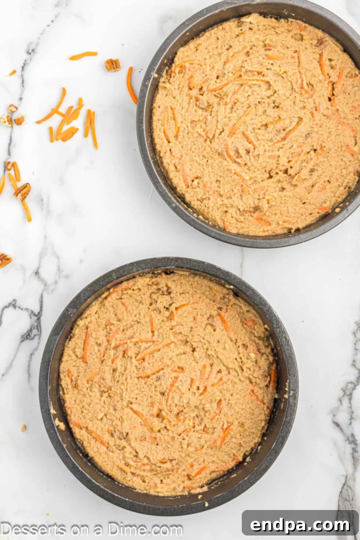 Carrot cake batter evenly poured into two prepared round baking pans.