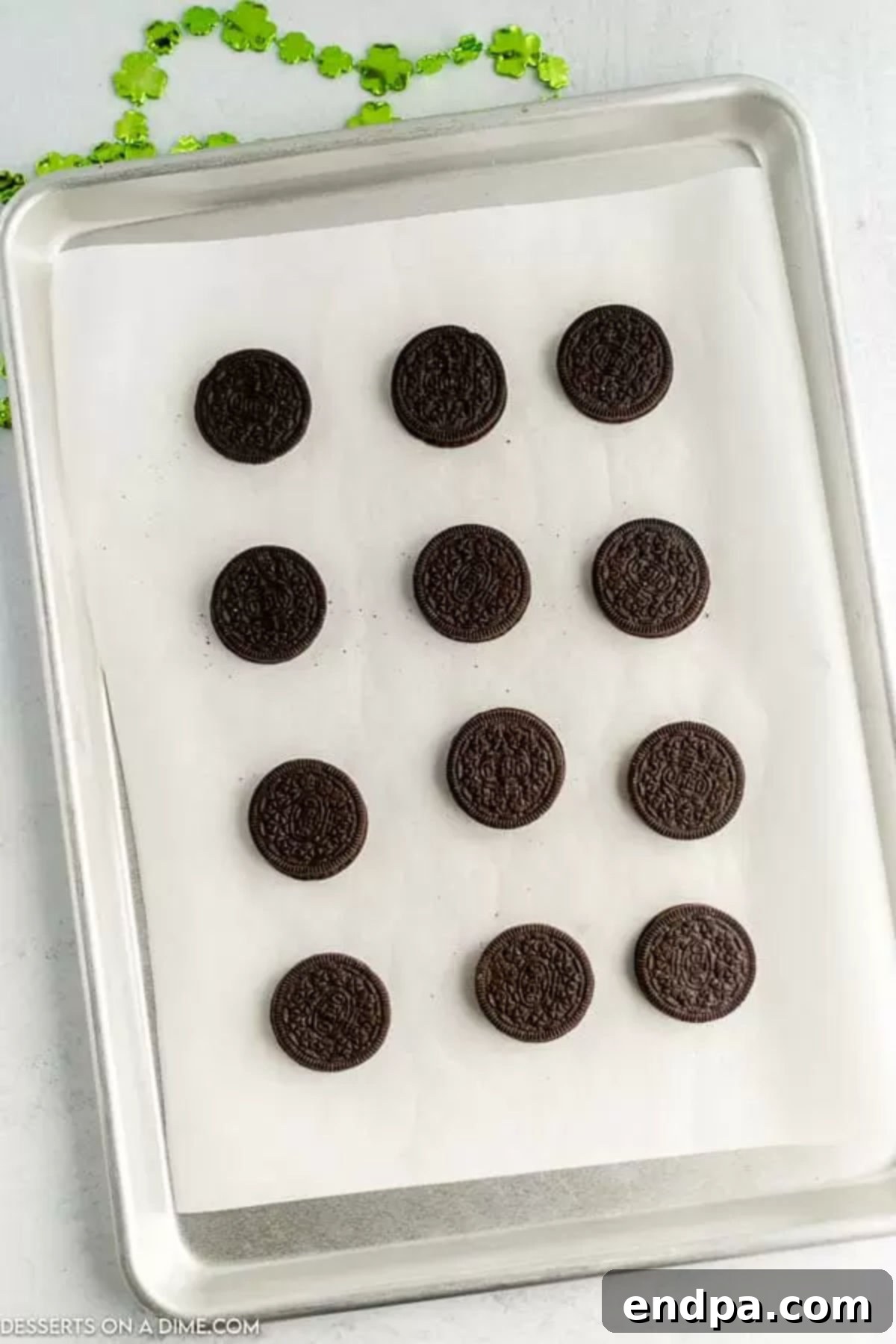 Oreos neatly arranged on a baking sheet, ready for the golden transformation.