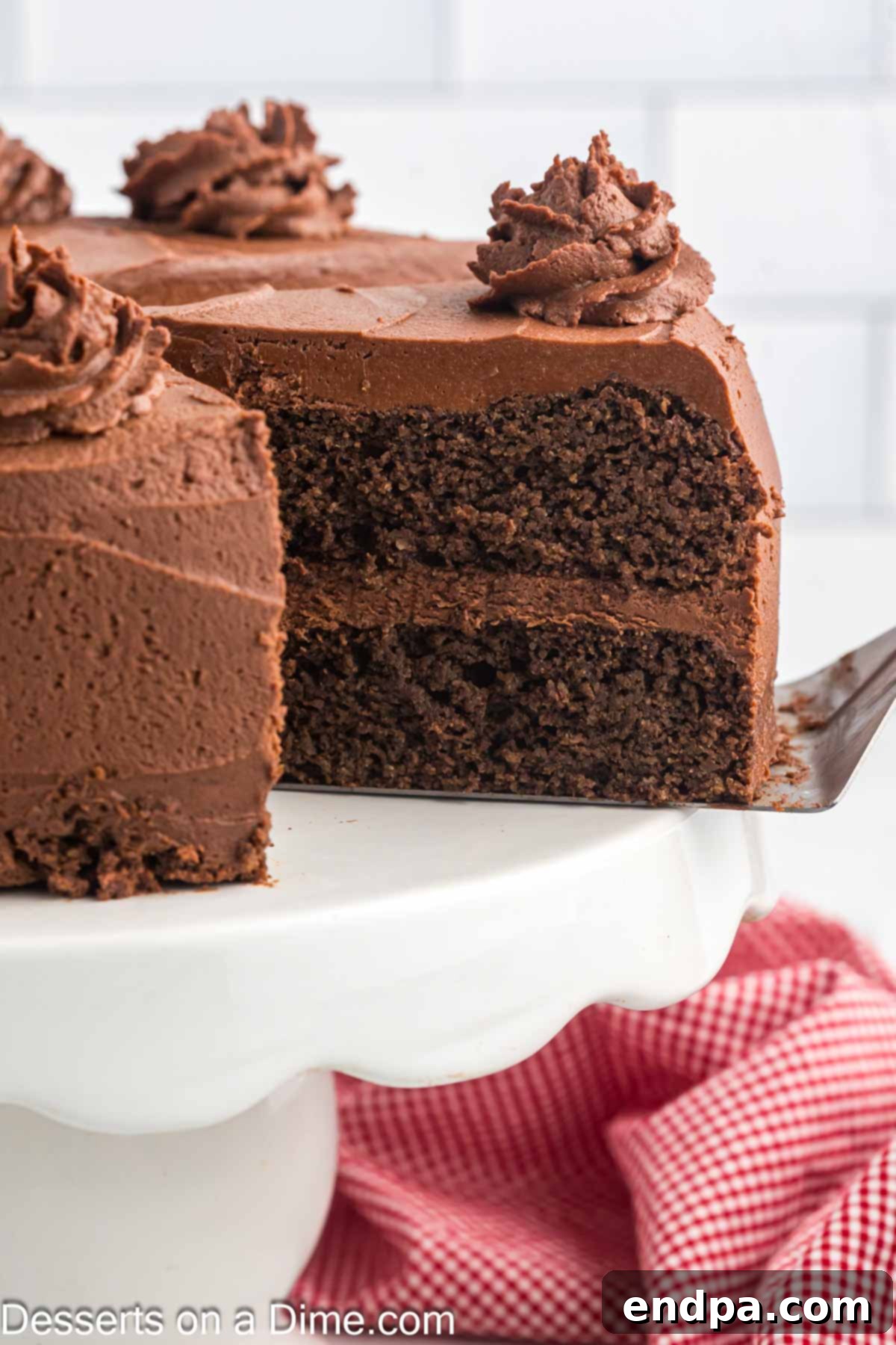 Decadent Keto Chocolate Dream 2 A slice of rich, dark Keto Chocolate Cake with chocolate frosting being served on a plate, highlighting its moist texture and inviting appeal.