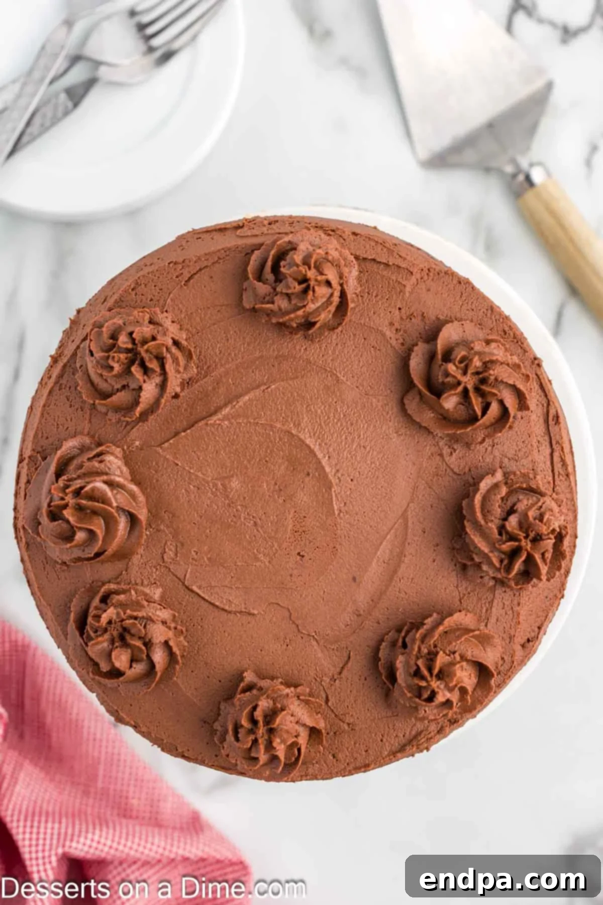 Decadent Keto Chocolate Dream 8 A beautifully frosted Keto Chocolate Cake, presented sliced and ready for serving, showcasing its rich, dark interior and smooth, creamy topping.