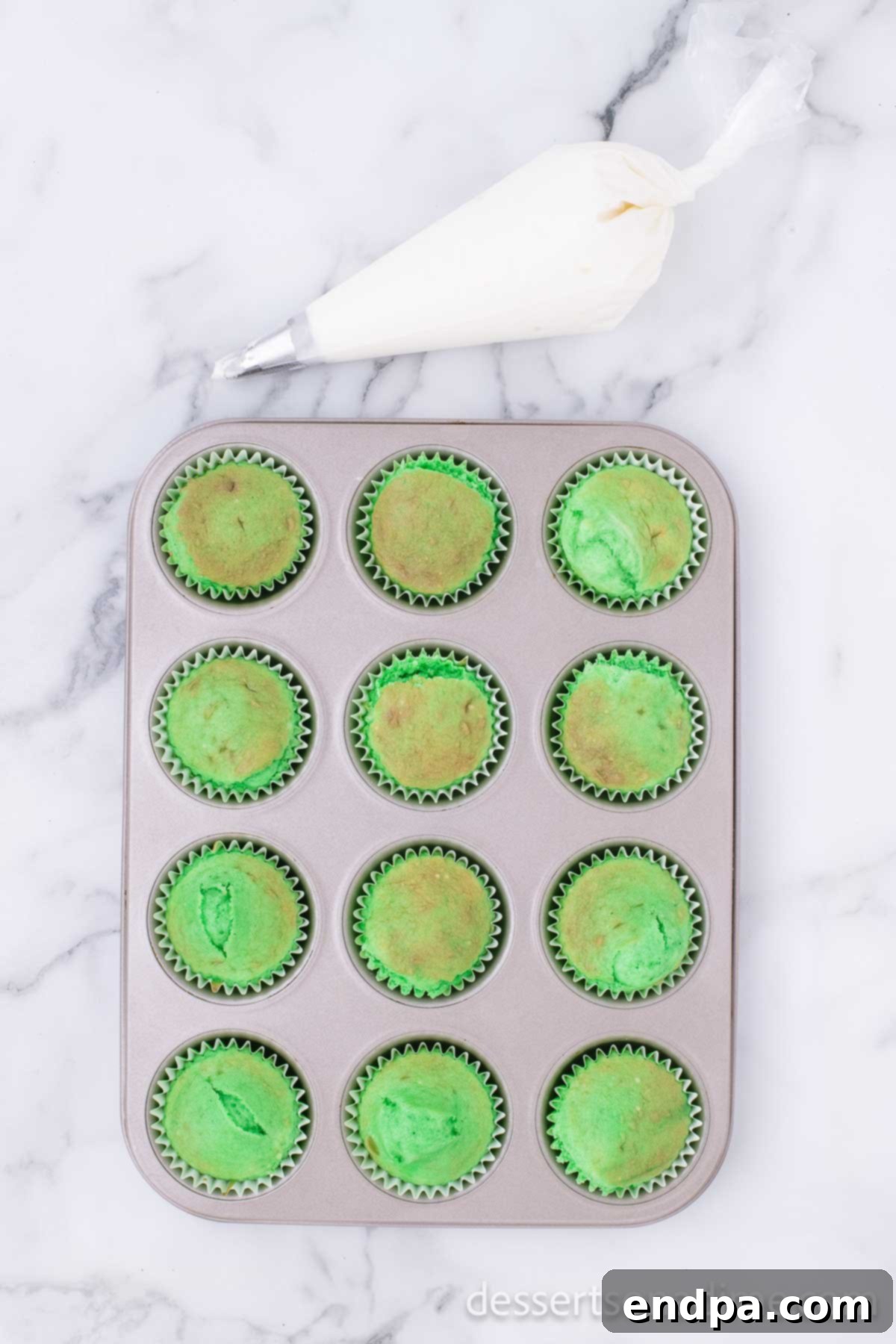 Lucky Green Cupcake Delights 5 Freshly baked green cupcakes cooling in a muffin pan on a wire rack.