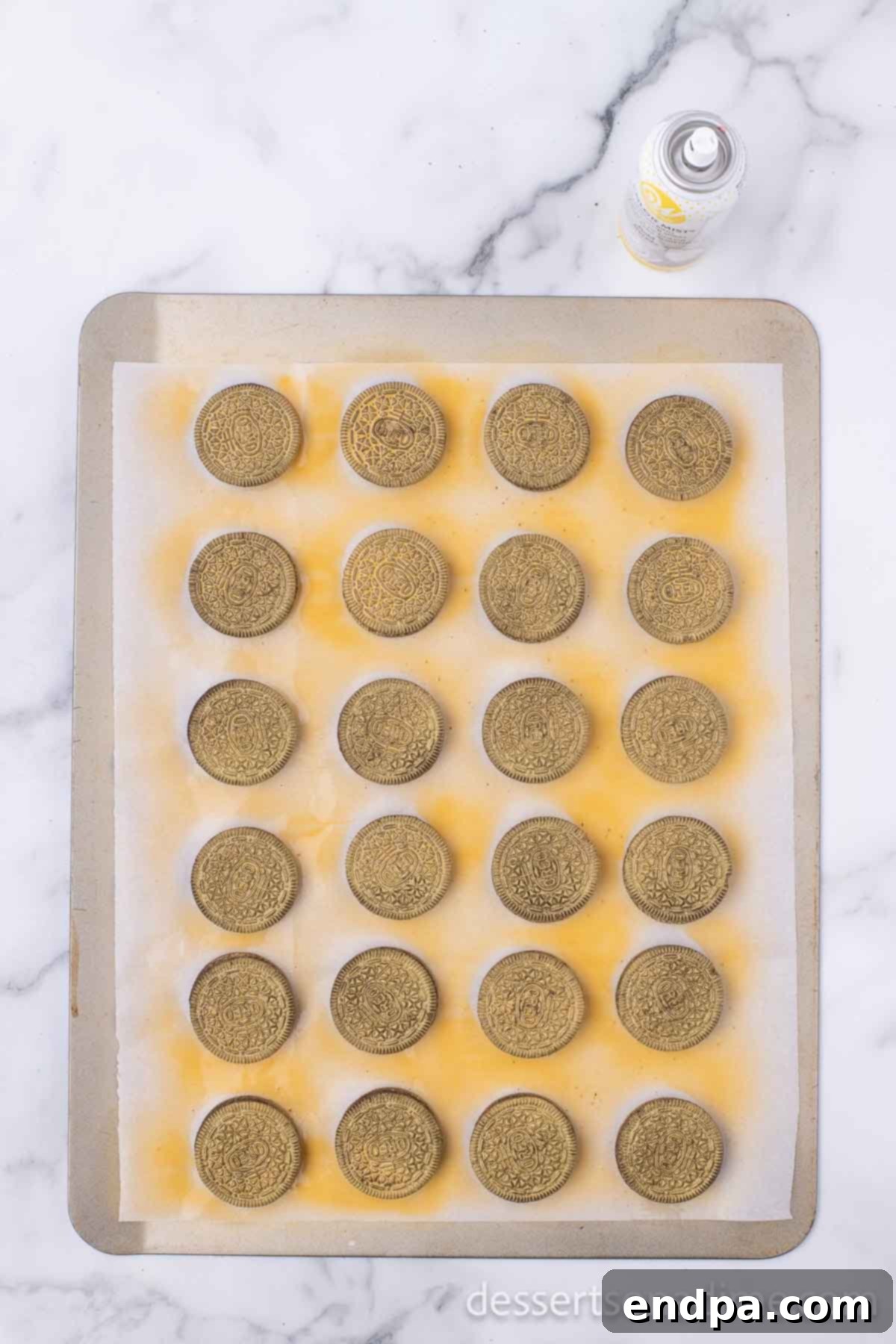 Lucky Green Cupcake Delights 6 Oreo cookies coated with gold spray, drying on parchment paper.