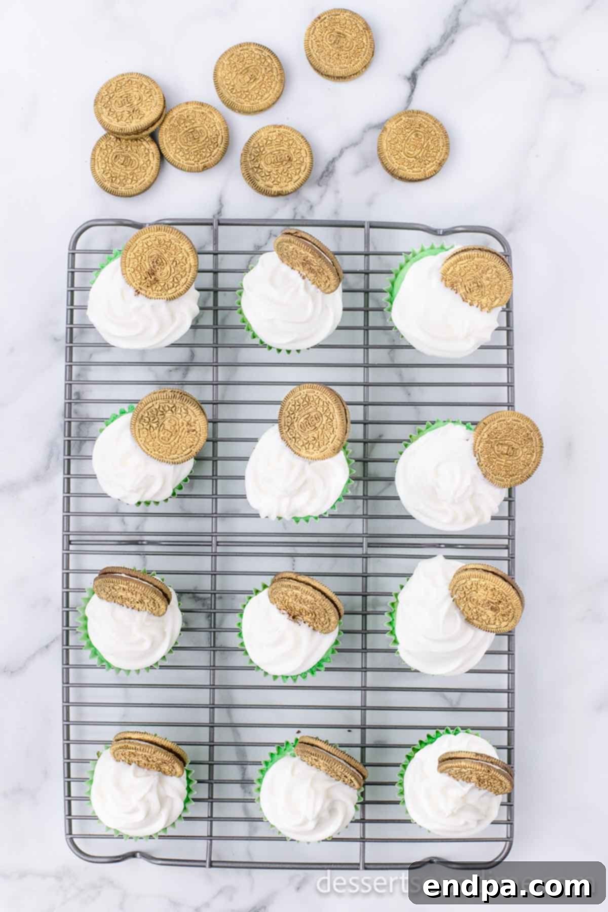 Lucky Green Cupcake Delights 7 Cupcakes frosted with white icing and topped with golden Oreo cookies.