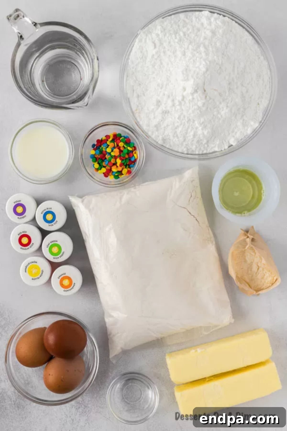 Ingredients for Rainbow Cupcakes including powdered sugar, cake mix, sprinkles, food coloring, oil, butter, eggs, and pudding mix.