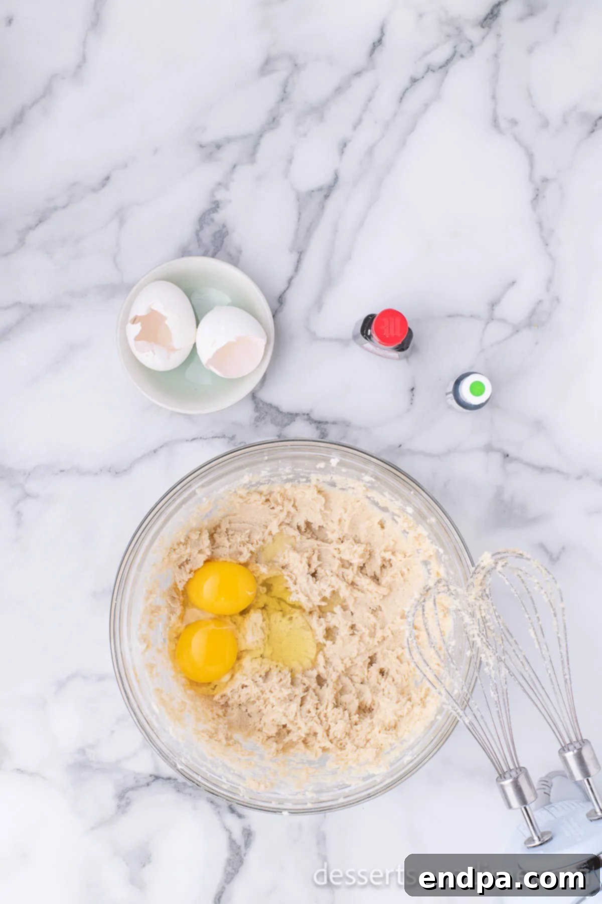 Adding room temperature eggs one at a time to the creamed butter and sugar mixture.