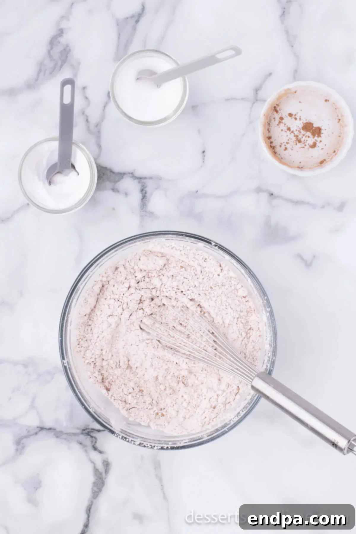 Mixing bowl with dry ingredients including flour, cocoa powder, and baking soda. 