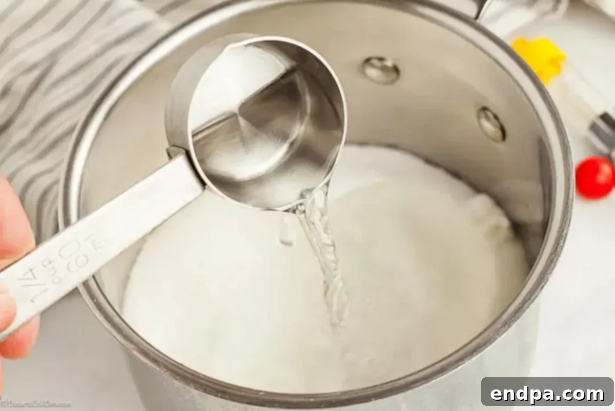 Water, sugar, and corn syrup being combined in a saucepan for the peanut brittle base.