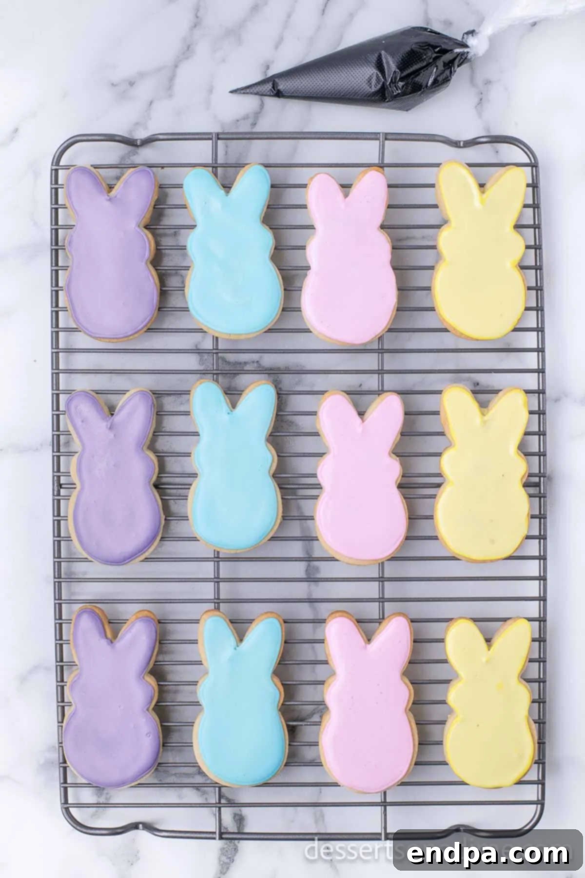 Hoppy Easter Cookie Creations 12 Decorated Easter bunny cookies with pastel royal icing, in the process of setting.