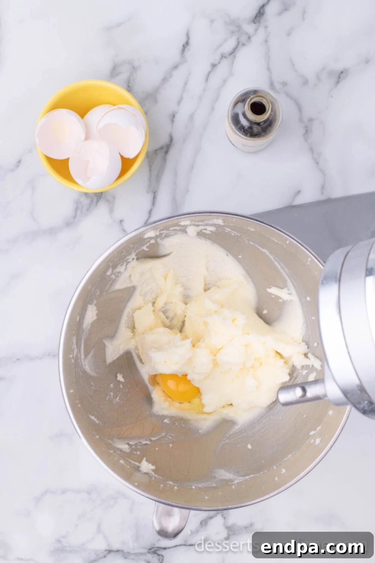 Hoppy Easter Cookie Creations 5 Four eggs added to the creamed butter and sugar mixture in a mixing bowl.